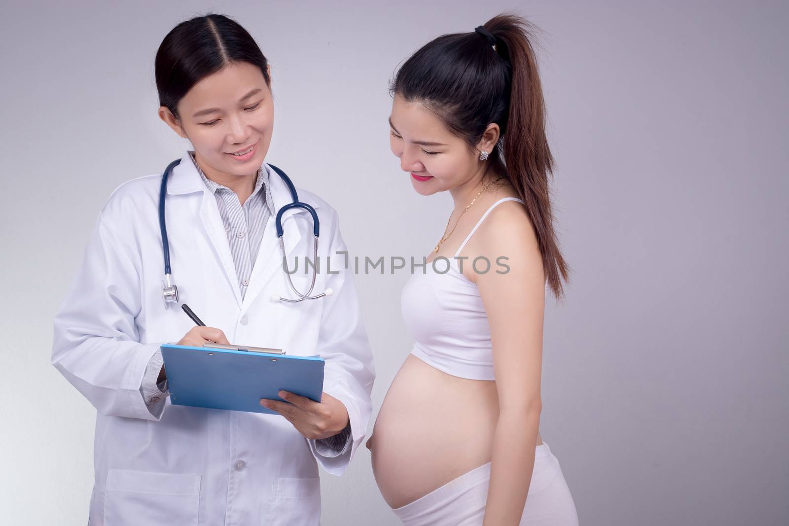 Pregnancy, motherhood, people, medicine and fertility concept - happy pregnant woman with doctor at maternity hospital. by asiandelight