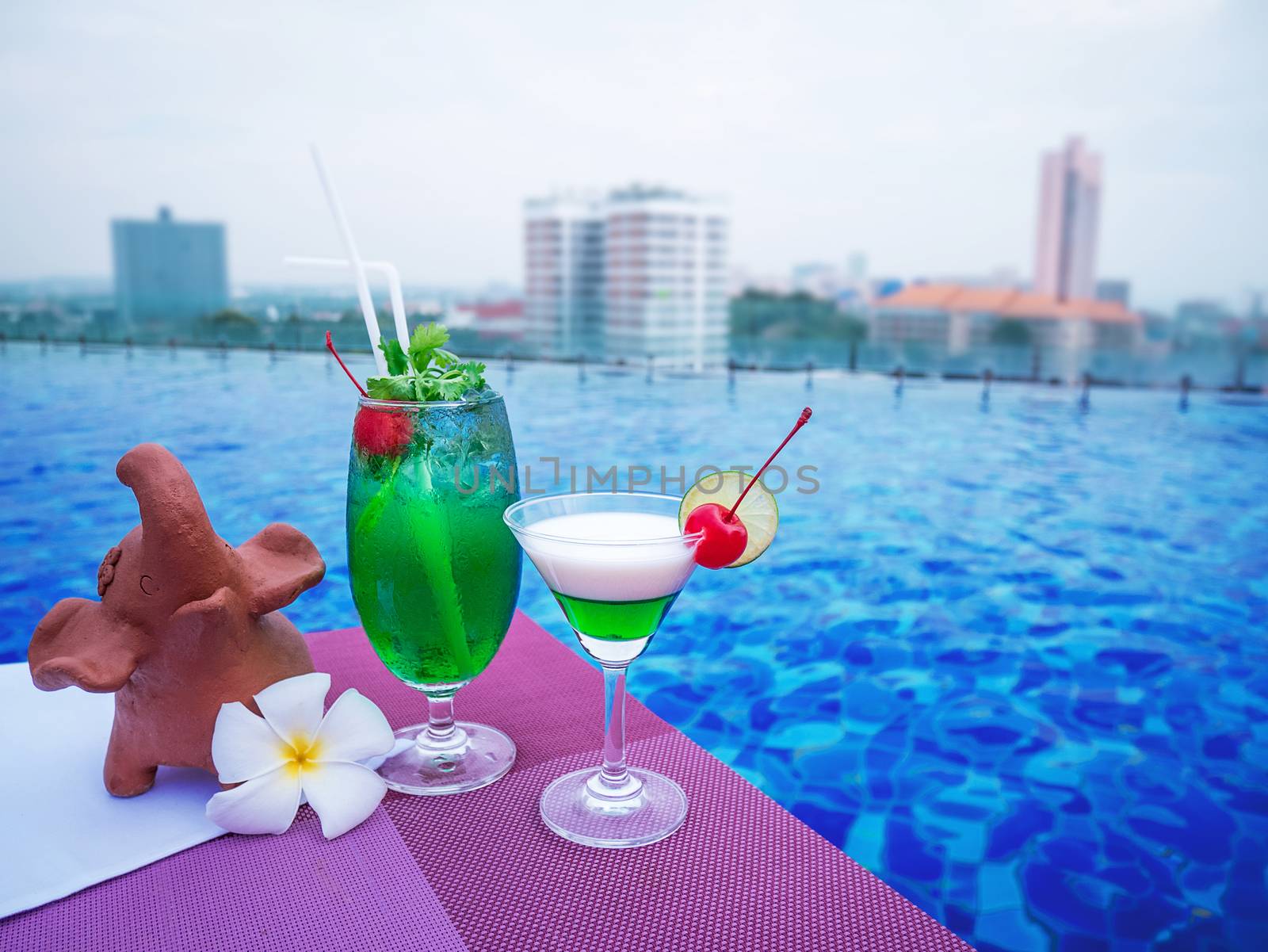 Cocktail glasses at swimimg pool with city view