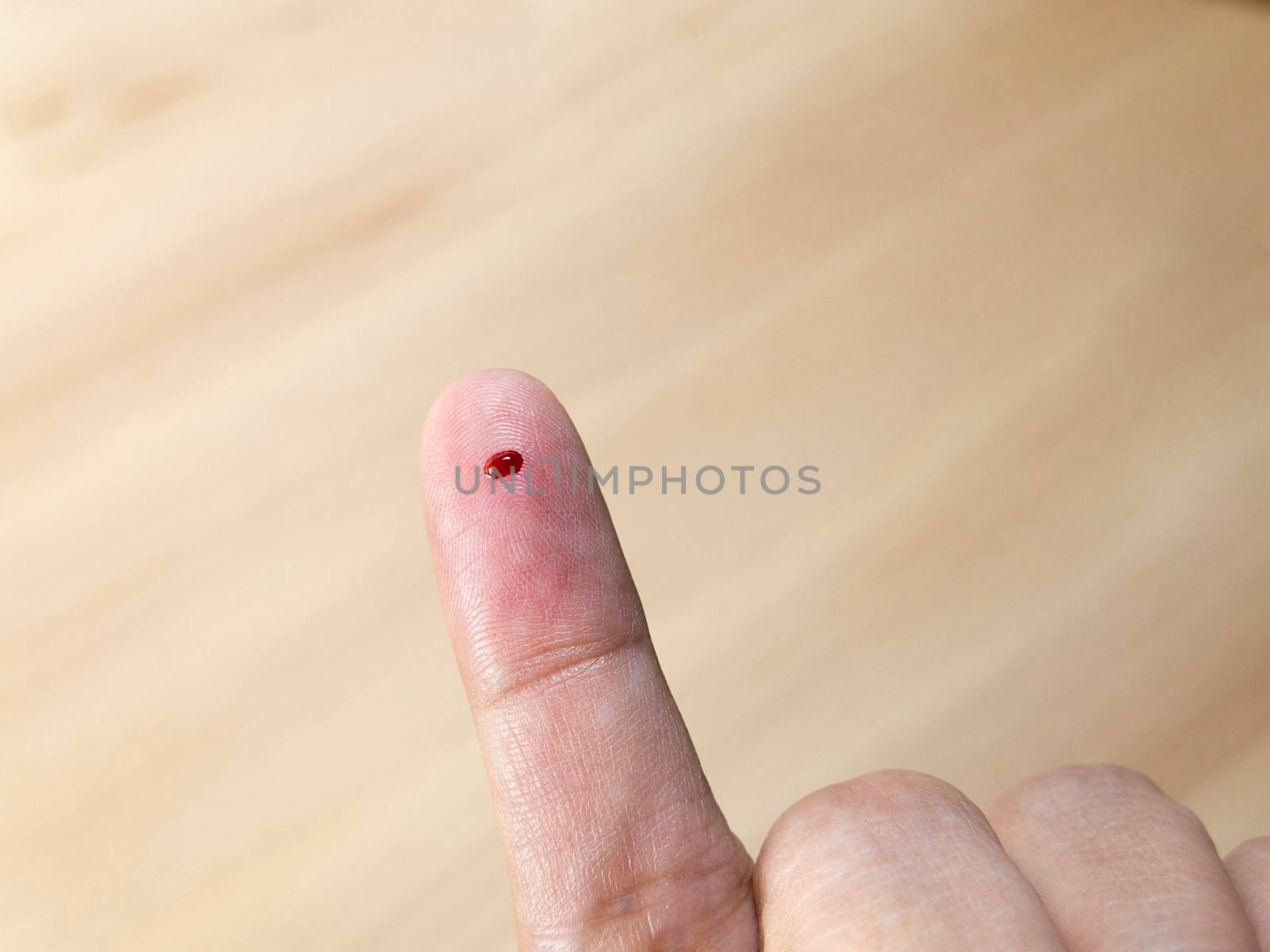 Close up of female finger with blood drop for blood testing by asiandelight