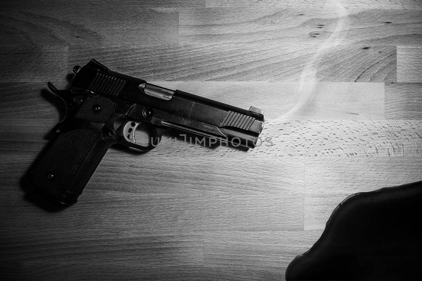 gun and blood on wooden table. black and white. robbery, murder, crime and security concept by asiandelight