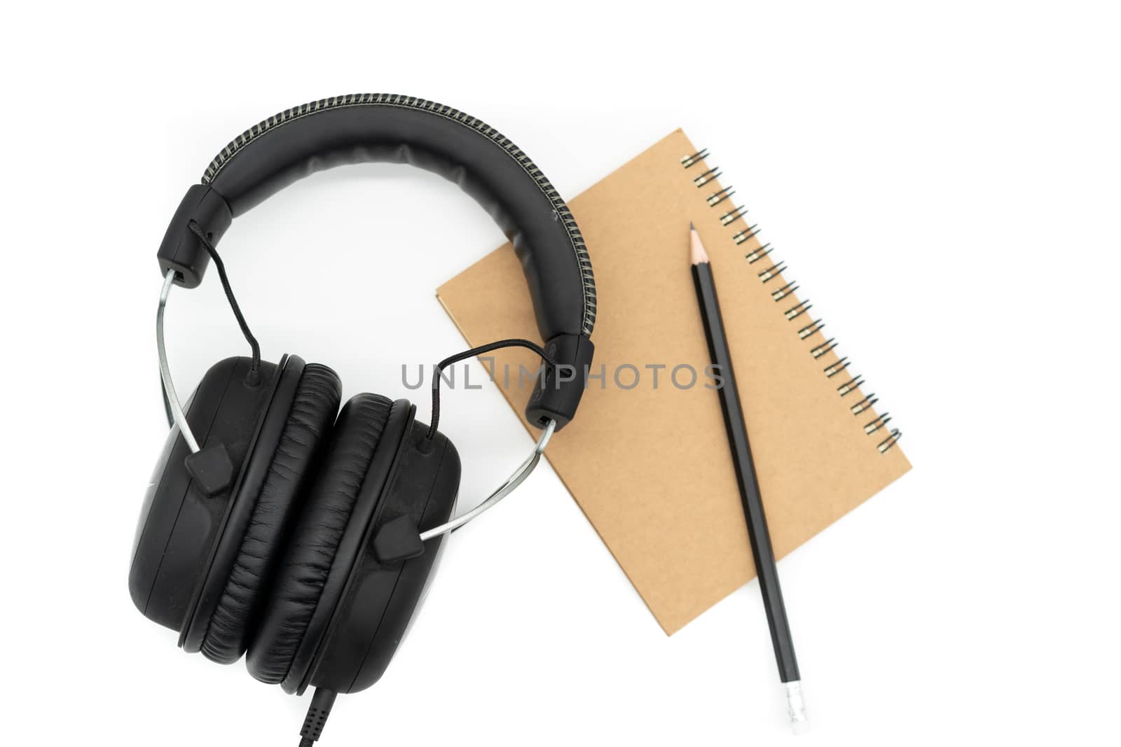 Brown books are placed under a black pencil and all black headphones are on a white background.