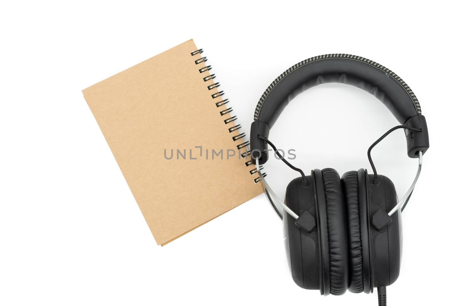 Place one book beside the headphones, all in the middle of the picture and all on a white background.