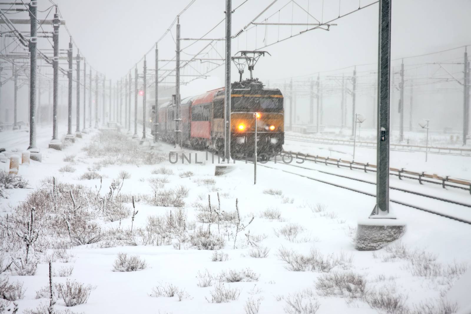 Train driving in snowstorm in winter in the Netherlands