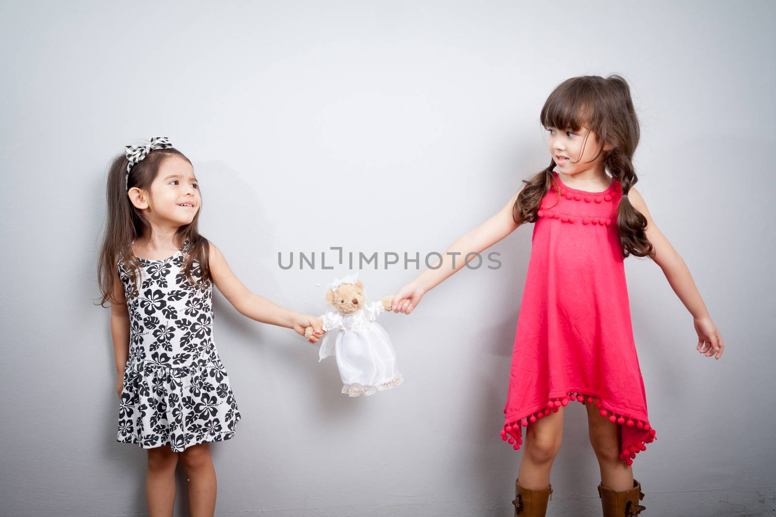 girl fight. the conflict between two sisters. the kids are fighting over a toy by asiandelight