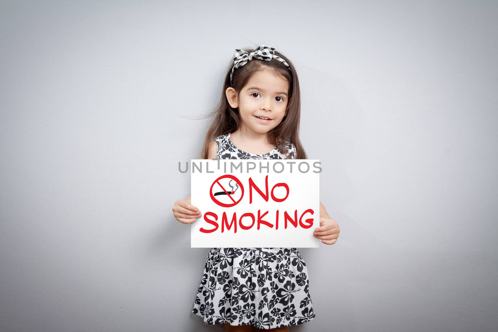 little cute girl with handwriting text no smoking on white paper. no smoking sign. stop smoking symbol. stop smoking. quitting from addiction concept.