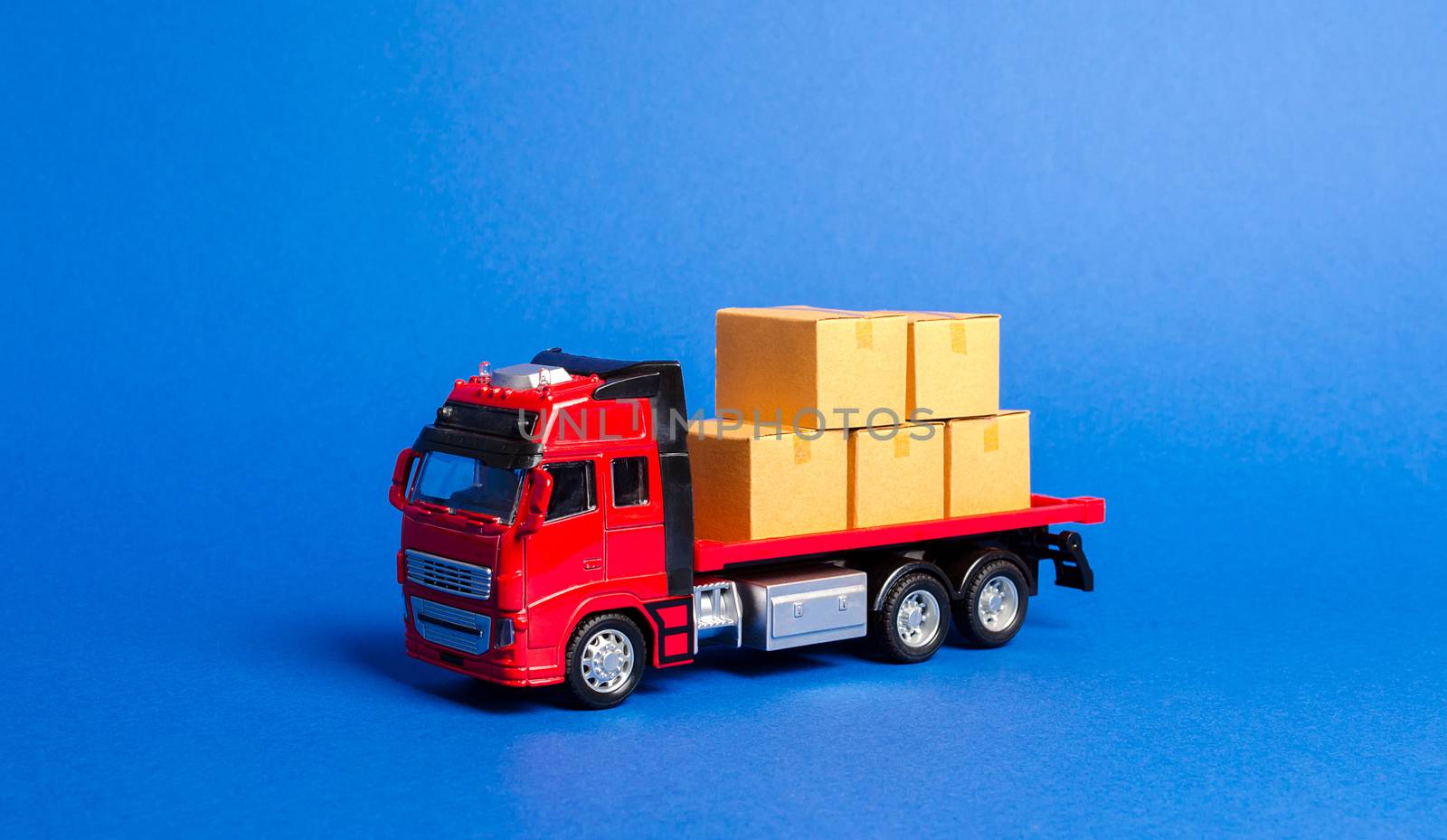 A red truck loaded with boxes. Transportation company. Services transportation of goods and products, logistics and infrastructure. Warehousing and supply. Optimization of delivery logistics.