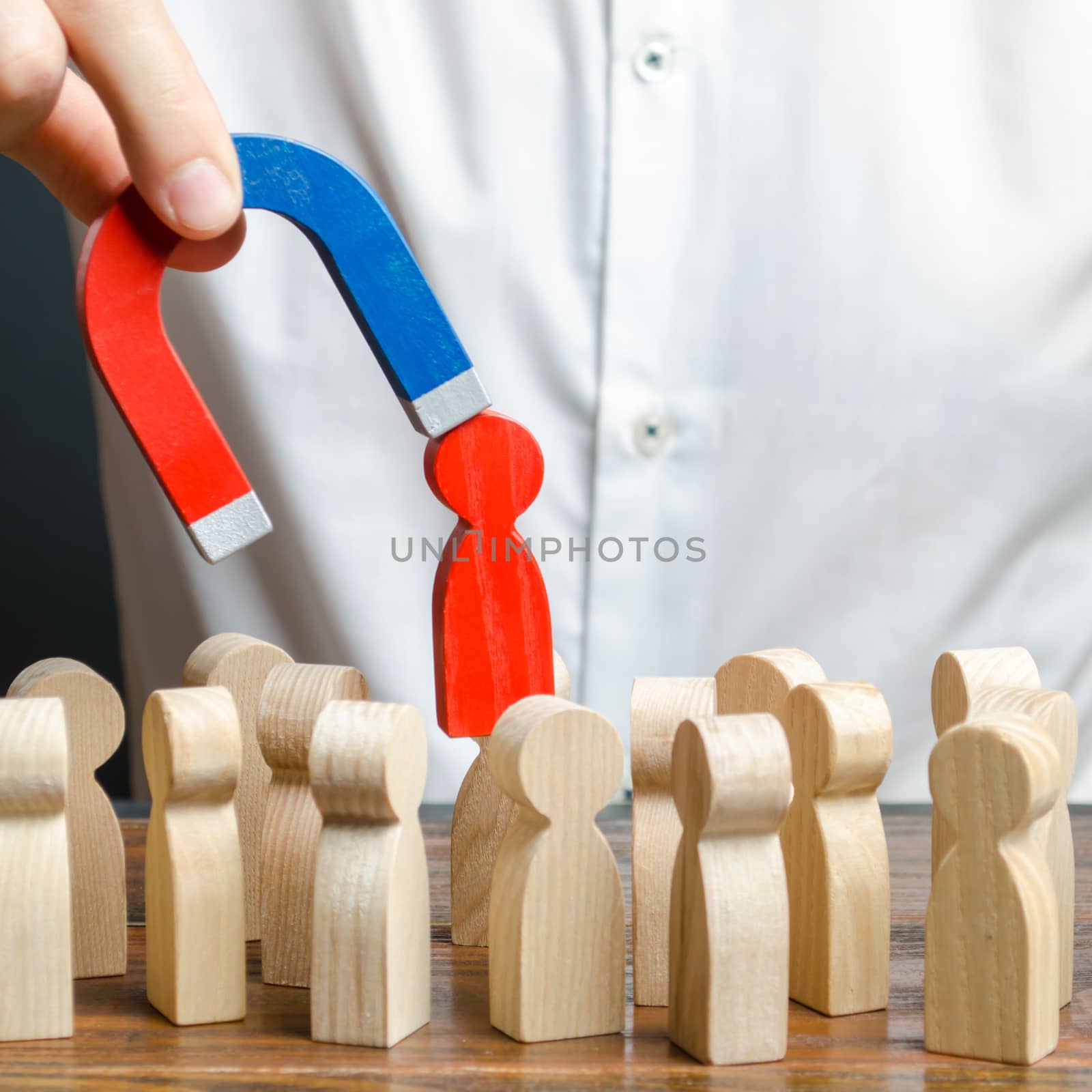 businessman pulls out a red figure of a man from the crowd with the help of a magnet. leader manages the business and forms a team. Increase team efficiency, productivity. toxic, non-competent worker. by iLixe48