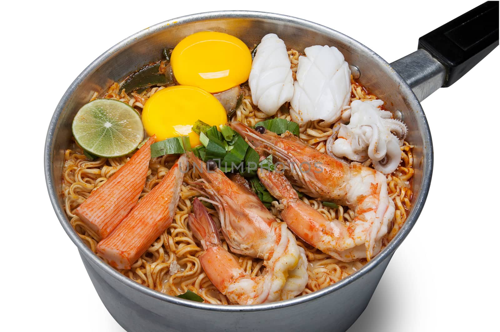 Bowl of spicy instant noodles isolated on white background. Topping with eggs, lemon, seafood, shrimp, squid, crab and coriander by asiandelight