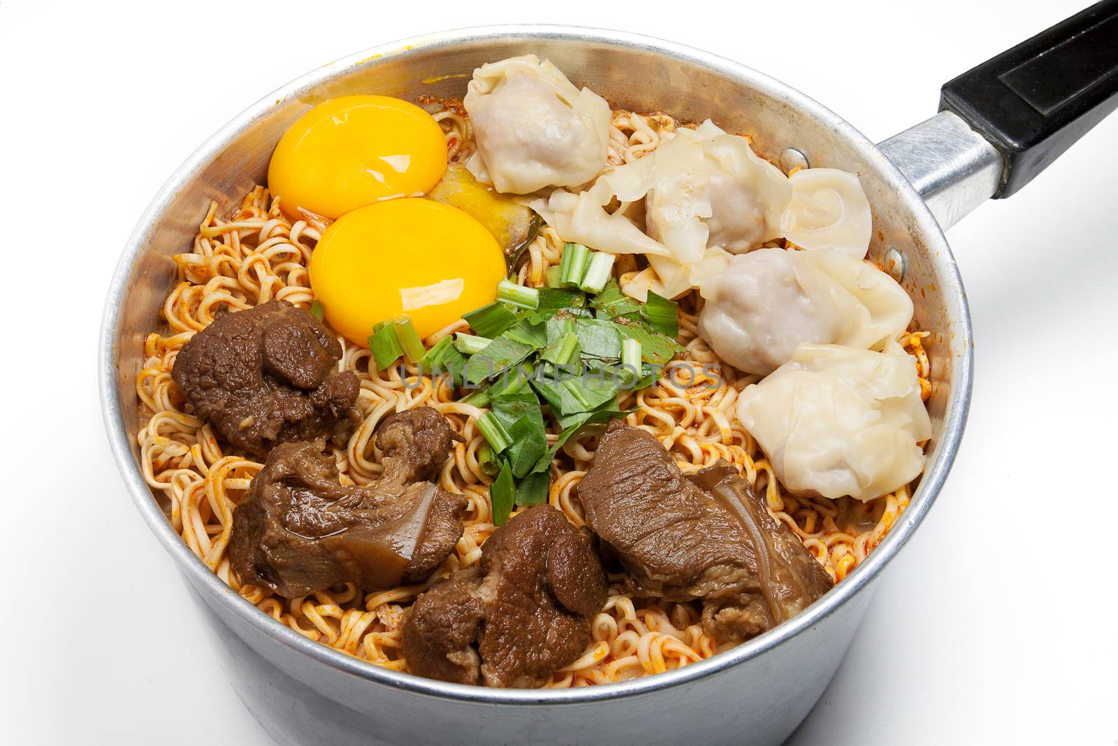 Pot of spicy instant noodles with red sauce isolated on white background. Topping with dumplings, egg , stewed pork and coriander