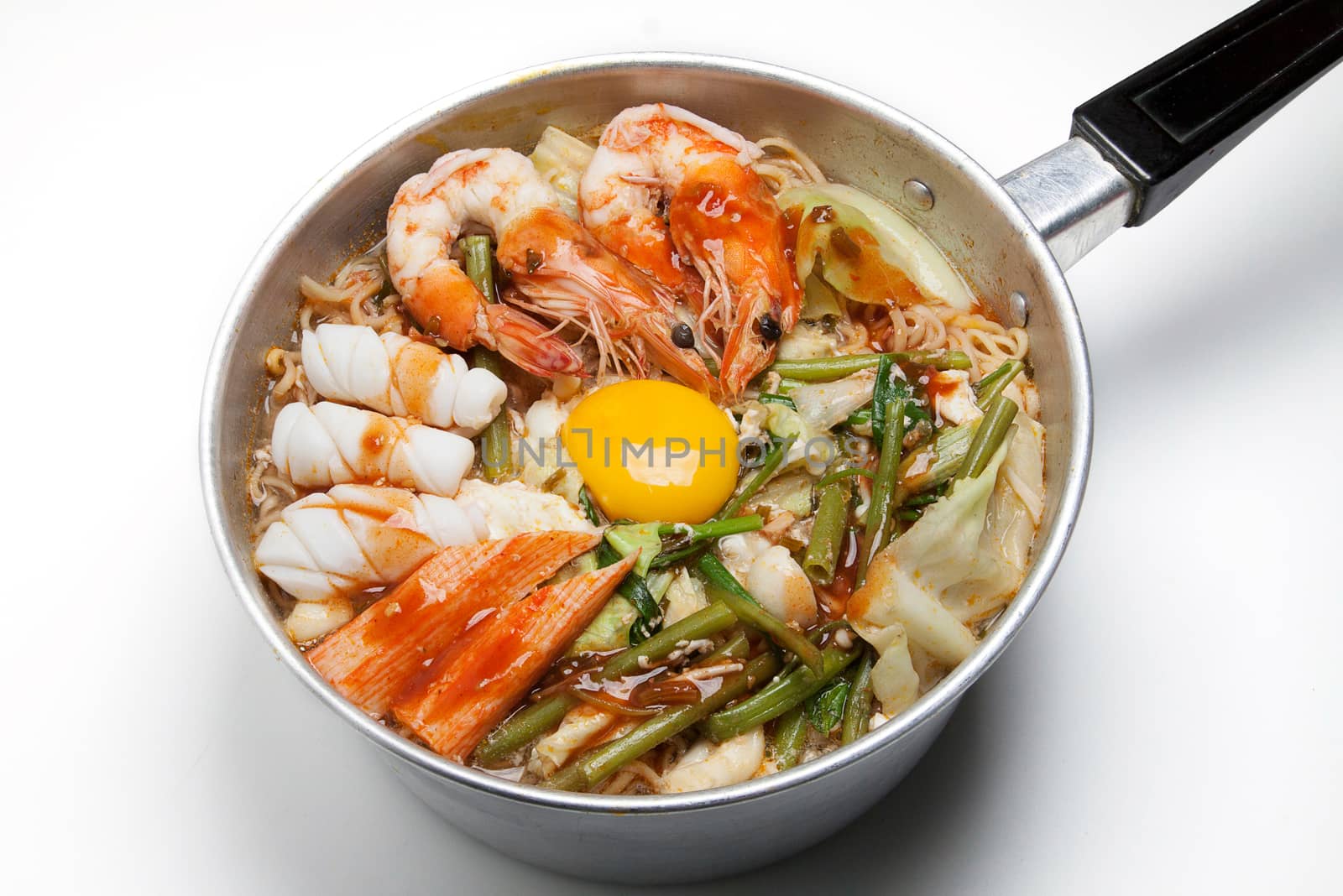 Pot of spicy instant noodles with sukiyaki sauce isolated on white background. Topping with egg, seafood , shrimp, squid, crab and coriander by asiandelight
