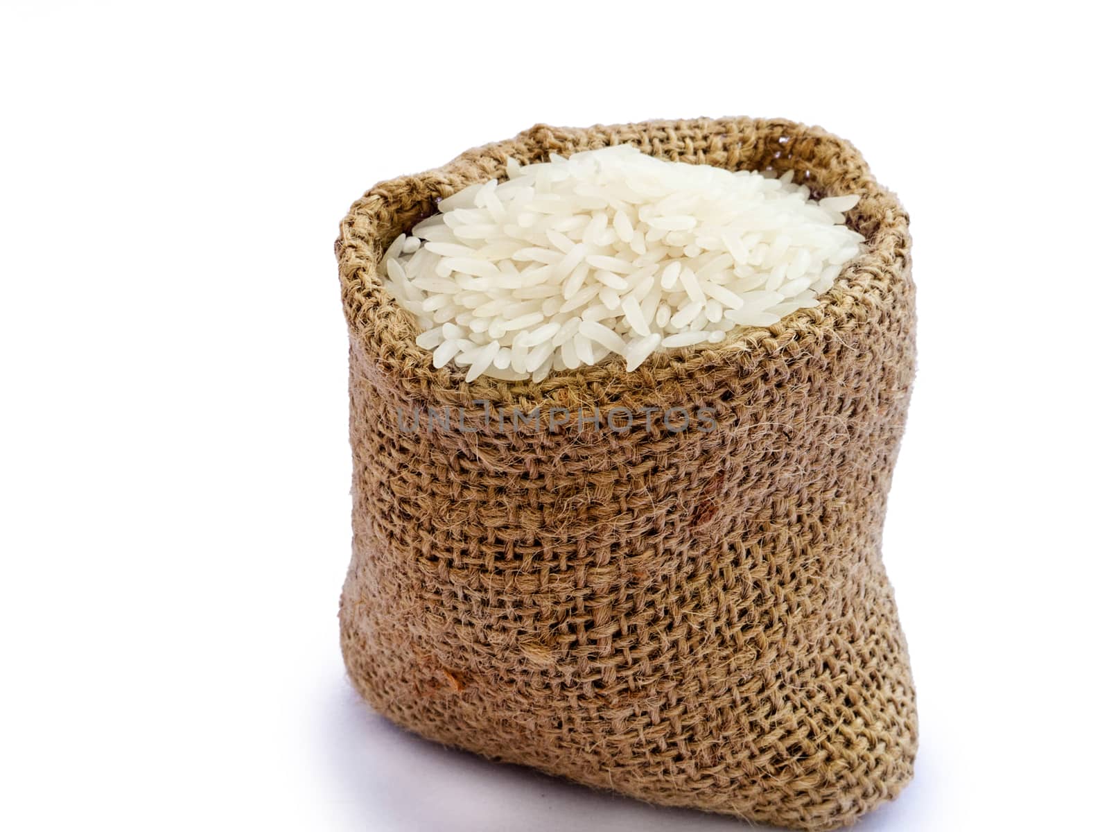 Thai jasmine rice in sack, white rice on burlap sack background with rice grain close up by asiandelight