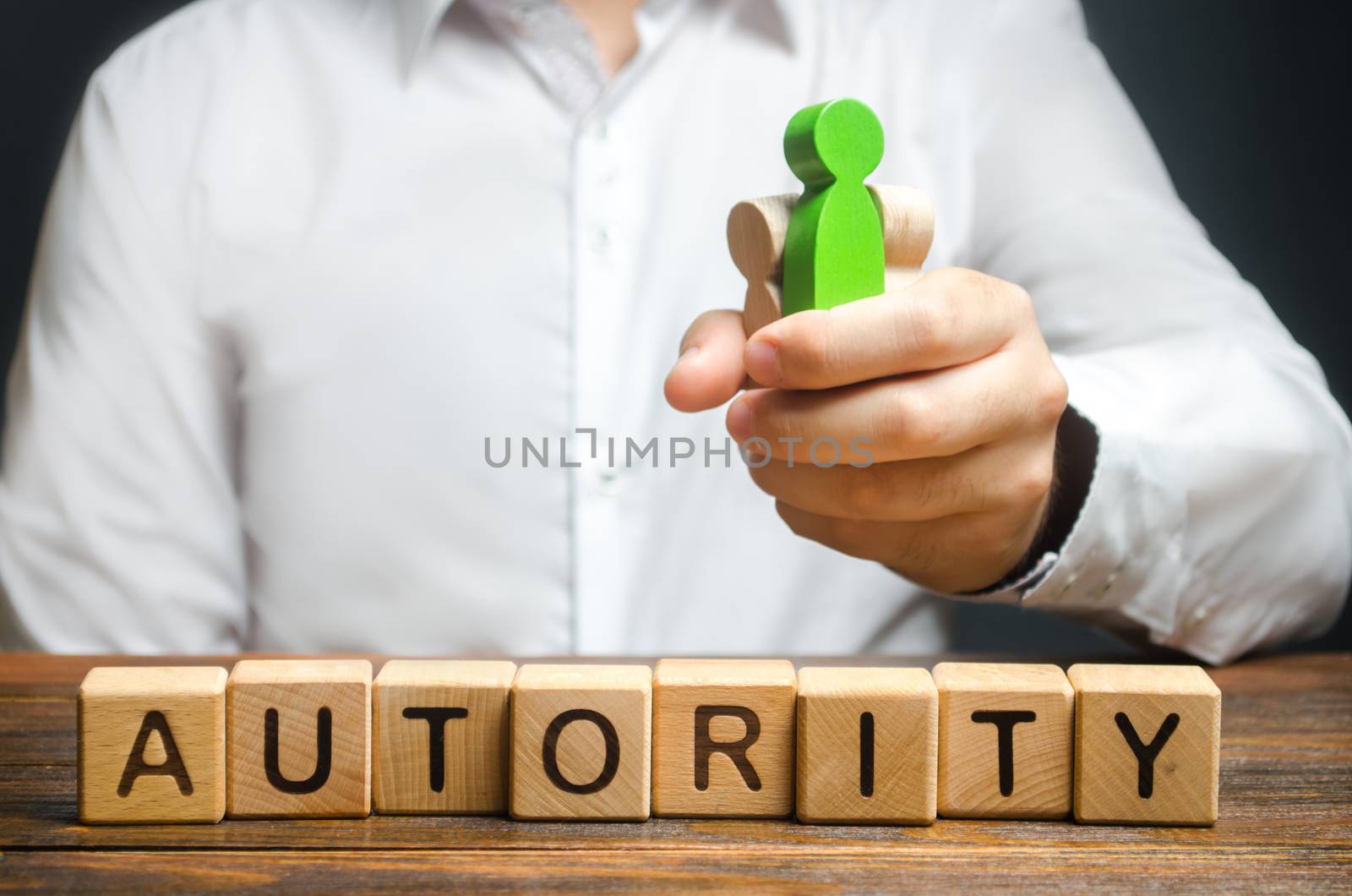 A man holds figures of people in a fist and the word Authority. High status and respect, reputation and importance. Business leader or crime boss. Submission and management control employees by iLixe48