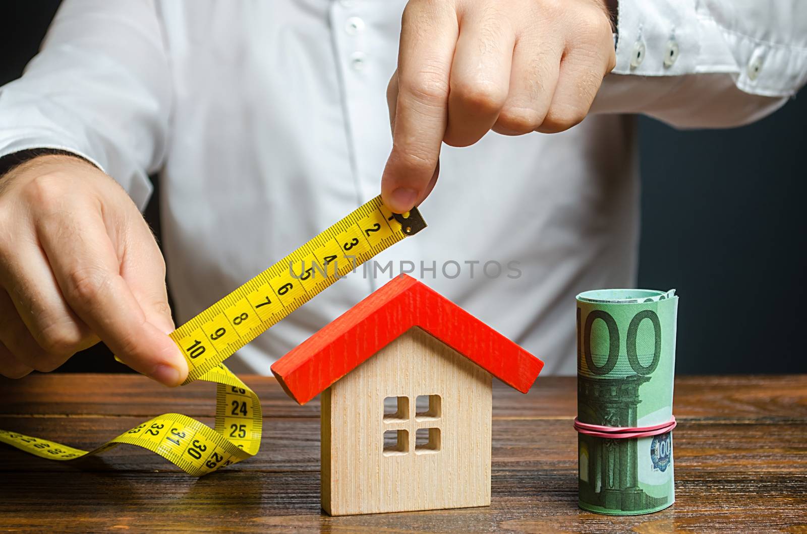 A man measures and evaluates a house. Fair value of real estate and housing. Property valuation. Home appraisal. Legal deal. Apartment purchase sale. Creating and designing a building project.