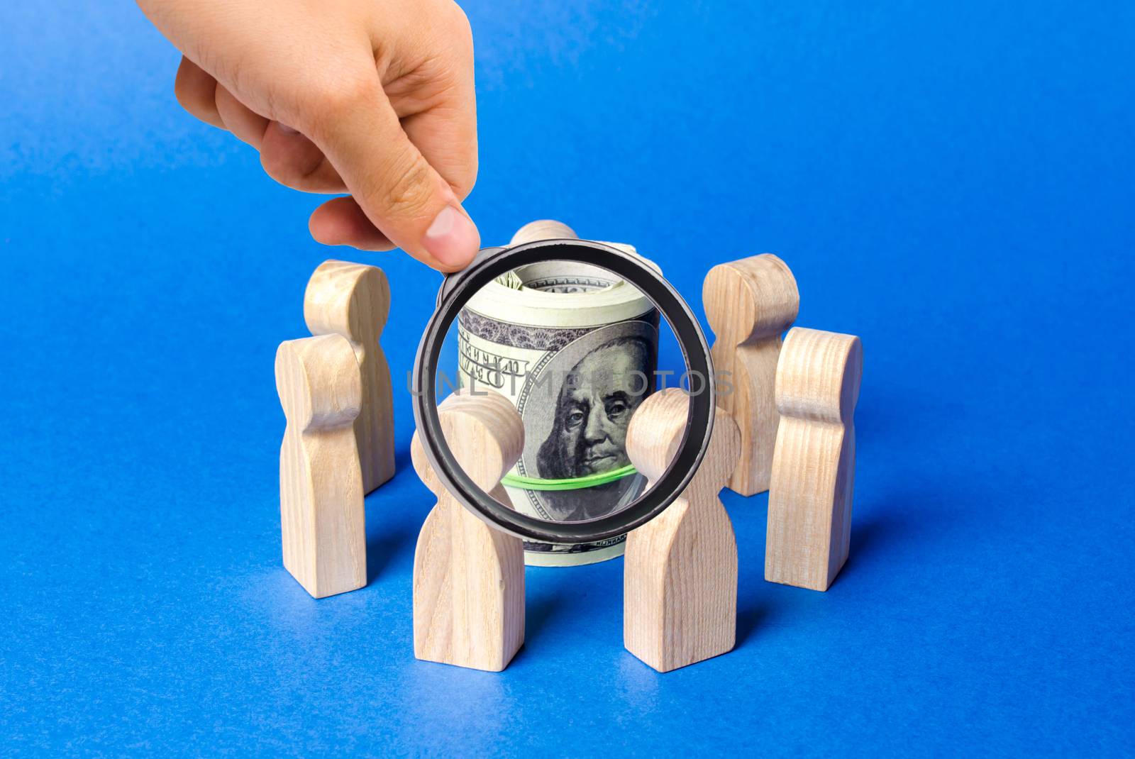 A magnifying glass looks at bundle roll of dollars surrounded by figures of people. Concept of raising money for a startup or idea, crowdfunding. The adoption of budget money by contractors by iLixe48