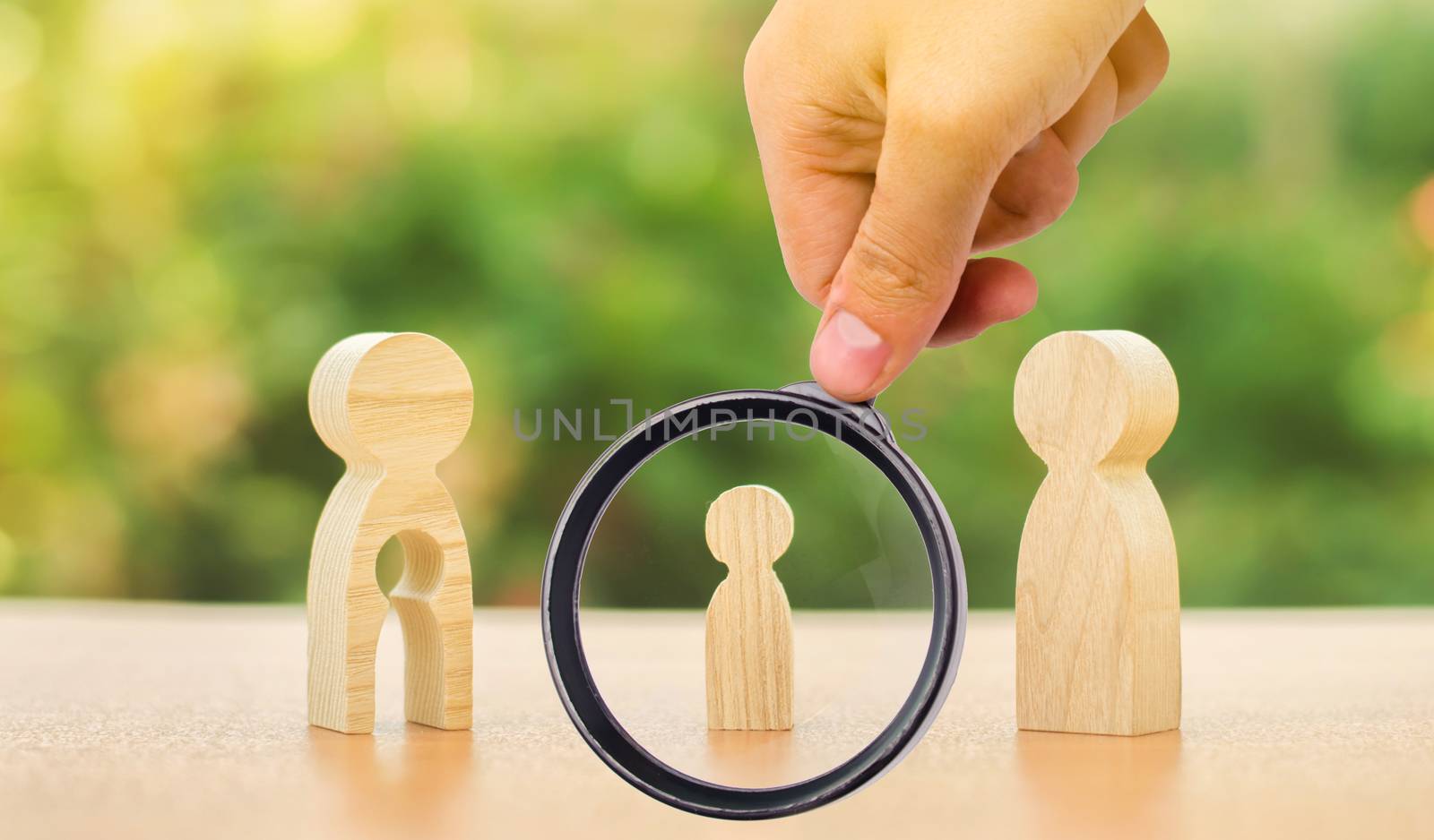 A magnifying glass looks at a child's figure stands between father and mother. The child chooses which parent to live with after their divorce. Guardianship over child. interest of child by iLixe48