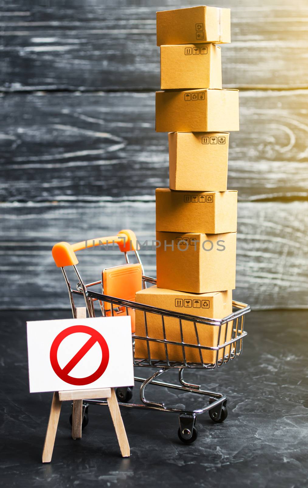 Trading cart with boxes and an easel with a prohibition symbol NO. Internet trade online shopping ban. Restriction on importation goods, proprietary for business. Sanctions and economic restrictions by iLixe48