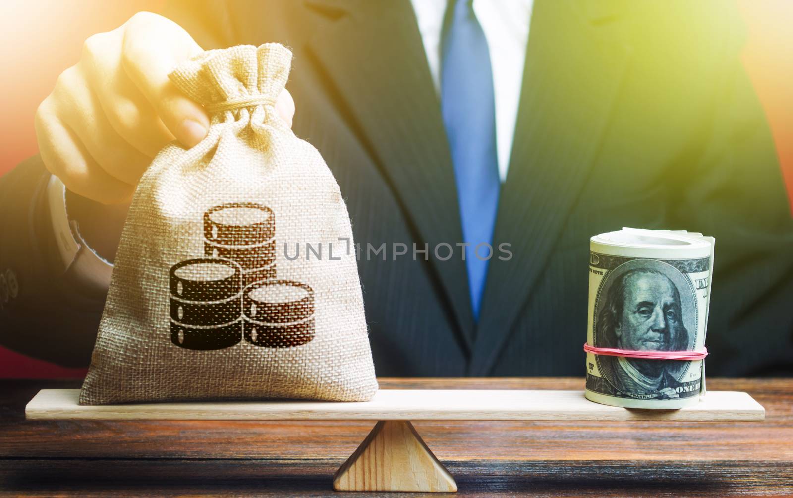 A man puts a money bag on the scales opposite to the dollar. Exchange rate, comparison of economic indicators. Avoiding savings inflation. Investments in foreign currency bonds.