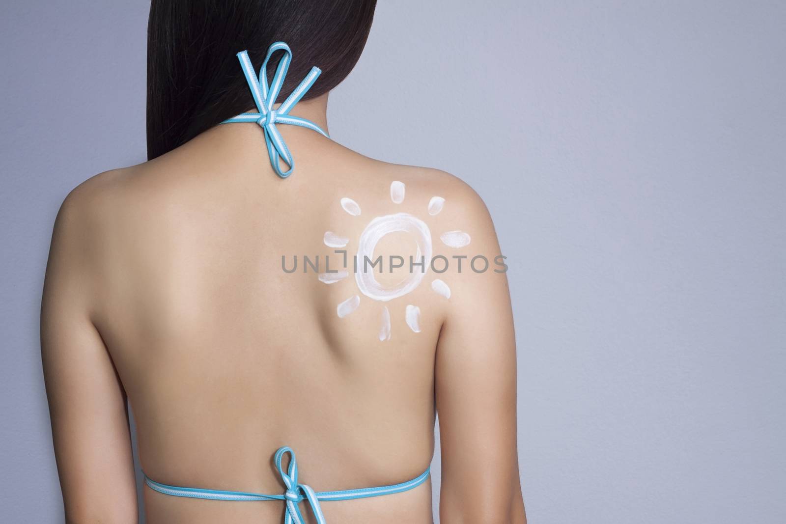 woman wear bikini applying sunscreen on her back. SPF and UV sunblock protection concept. Travel vacation