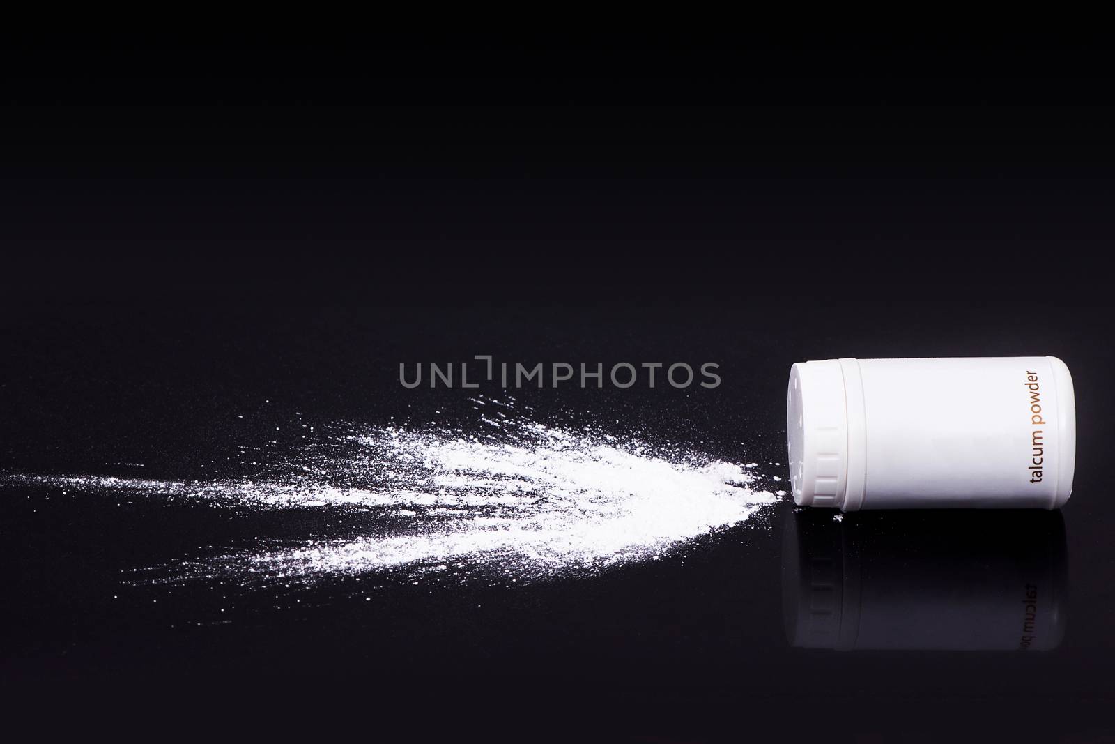 white talcum powder splash on black background, health concept by asiandelight