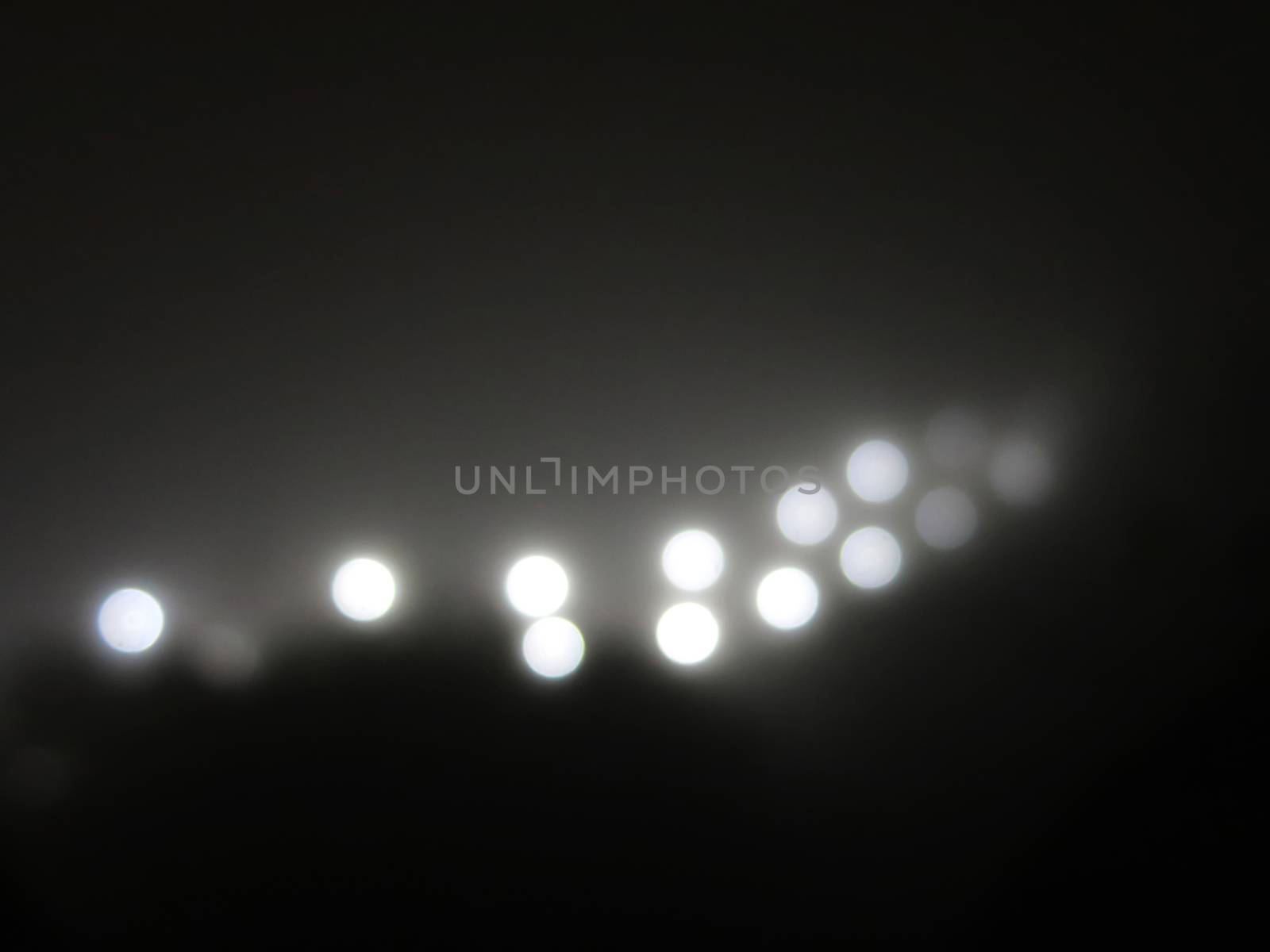 Abstract lights in the fog. Ray of bright white light from a street lamp in the fog. black and white by asiandelight