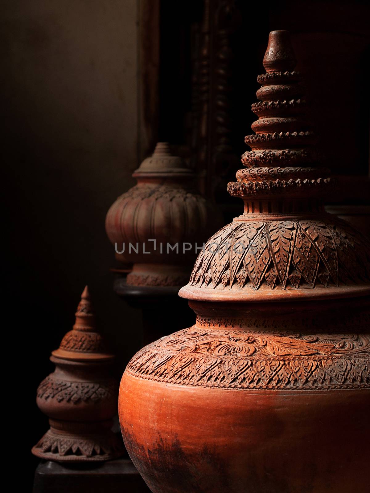 Pottery and other articles made of earthenware or baked clay. Old craft vintage pottery in Thailand. Light and shadow photography technique style. Selective focus at pattern design of retro pottery and earthenware