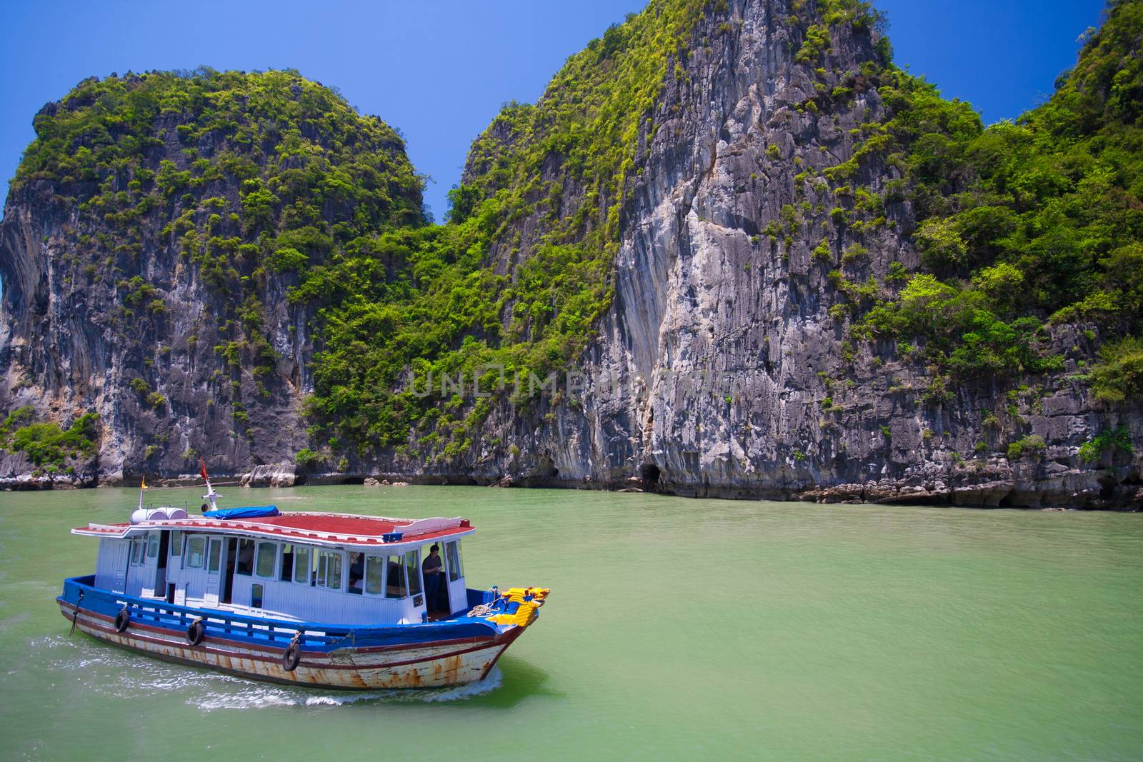 Popular famous tourist attraction in Vietnam. Tourist junk boat floating among limestone rocks at Halong Bay, Hanoi , South China Sea, landmark of Vietnam, Southeast Asia by asiandelight