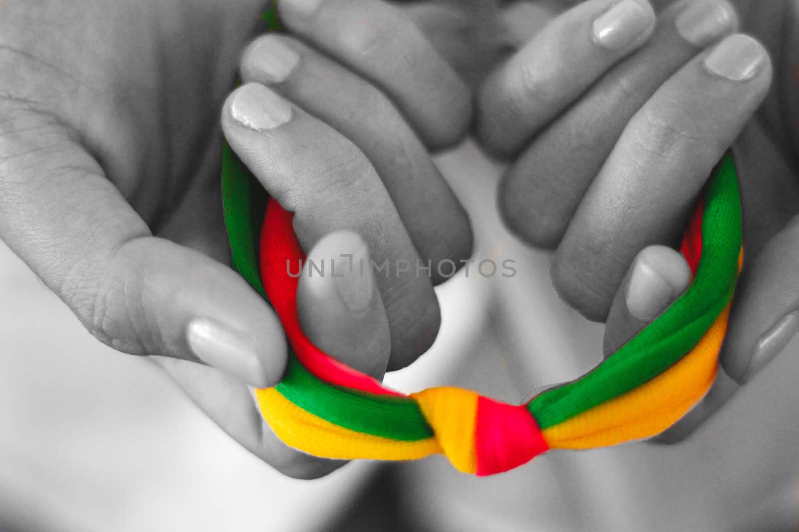Hand holding a rainbow colored ribbon to show concept of lgbtq, sexual freedom and pride month celebration