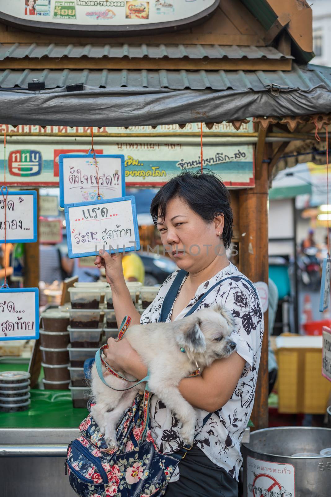 Prachuap Khiri Khan, Thailand - June 17, 2017 : Unidentified woman and the dog walk stroll shopping at Hua Hin night market. The famous night market for travel in Hua Hin is major tourist attraction.