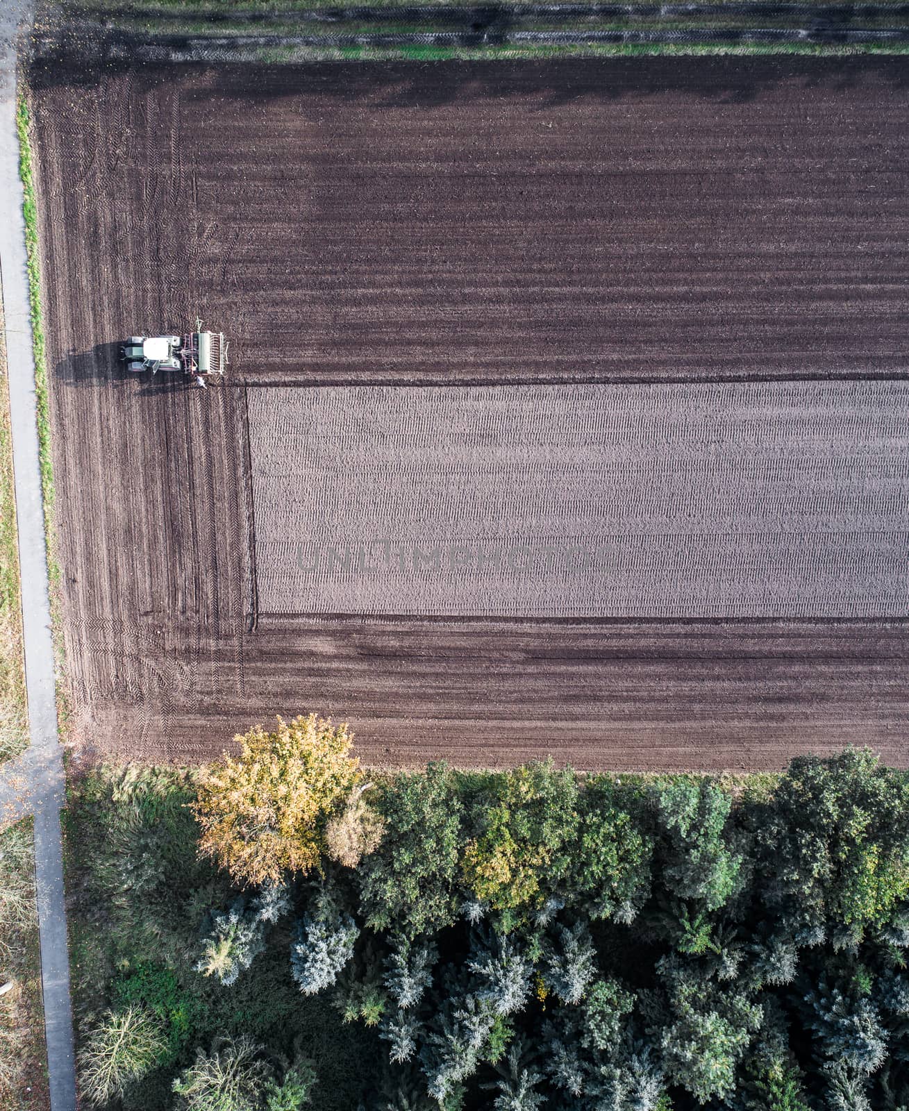 Aerial photograph with the drone, farmer ploughs a rectangular geometric pattern into his field in autumn
