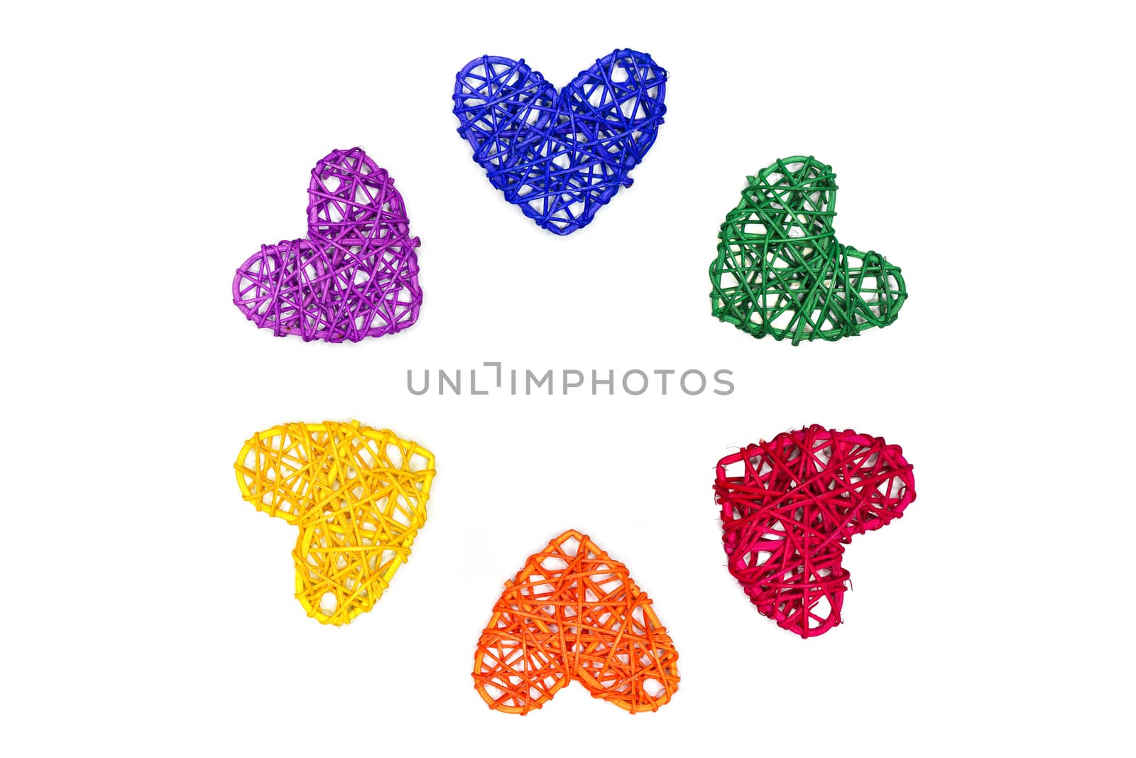 Rainbow color hearts made of natural rattan arranged in circle on white backgrouns. Celebrating love, romance, Pride Day.