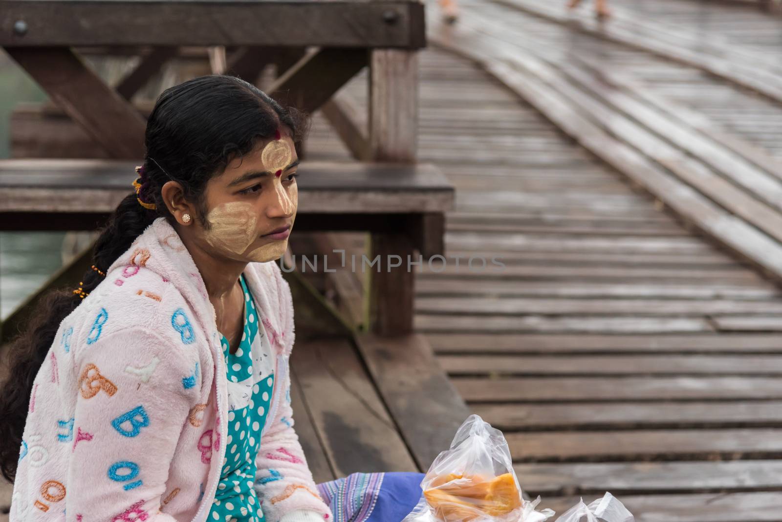 Kanchanaburi, Thailand - March 2, 2018 : Mon woman sale Samosa is snack fried filled puff with spicy sauce on Mon Bridge, Wooden Bridge in Tambon Nong Lu, Amphoe Sangkhla Buri, Chang Wat Kanchanaburi