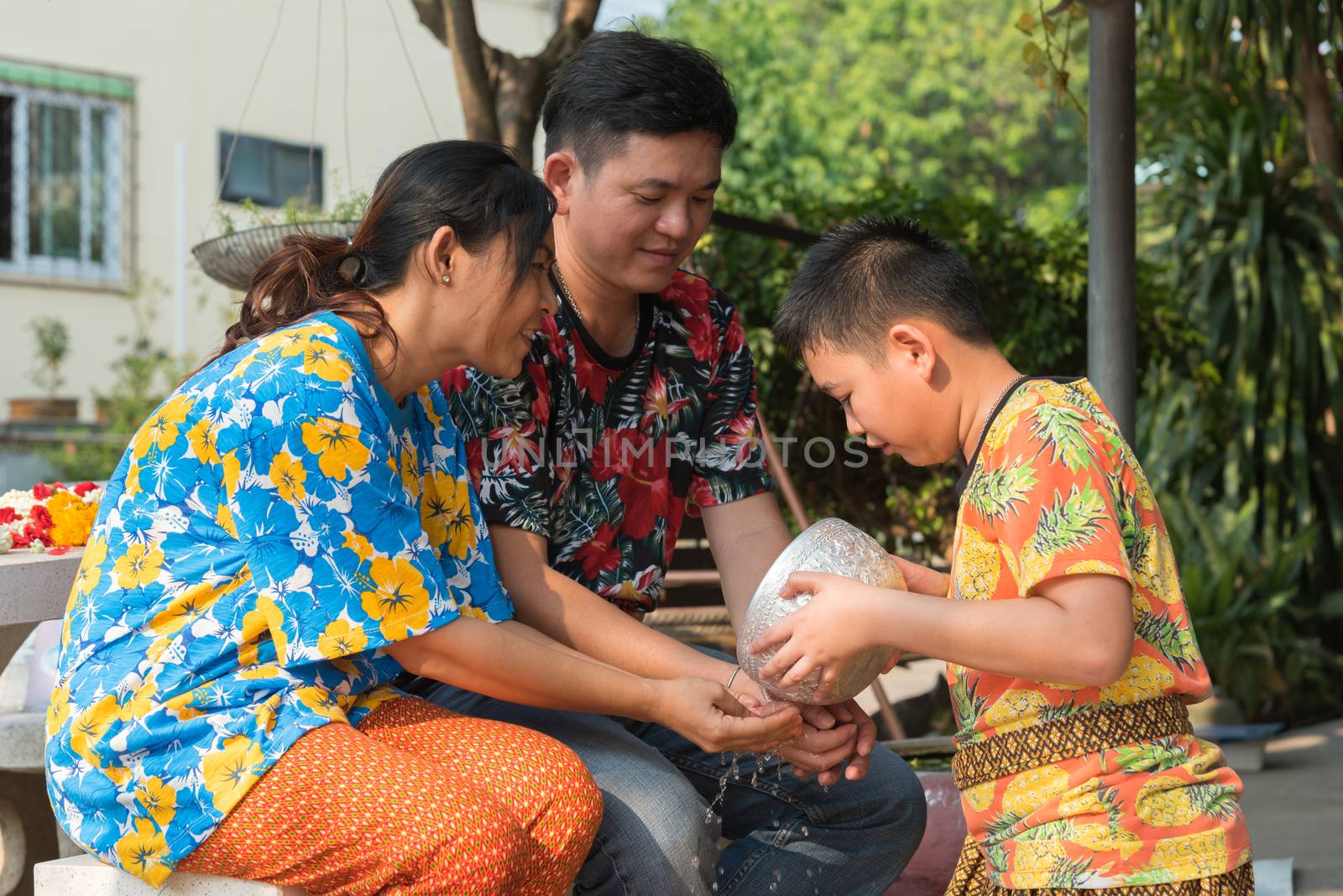 Ang Thong, Thailand - April 13, 2018 : Unidentified Asian young bathe with respect to parents by water have a jasmine and rose flower and aromatherapy in water in water bowl in Songkran Festival