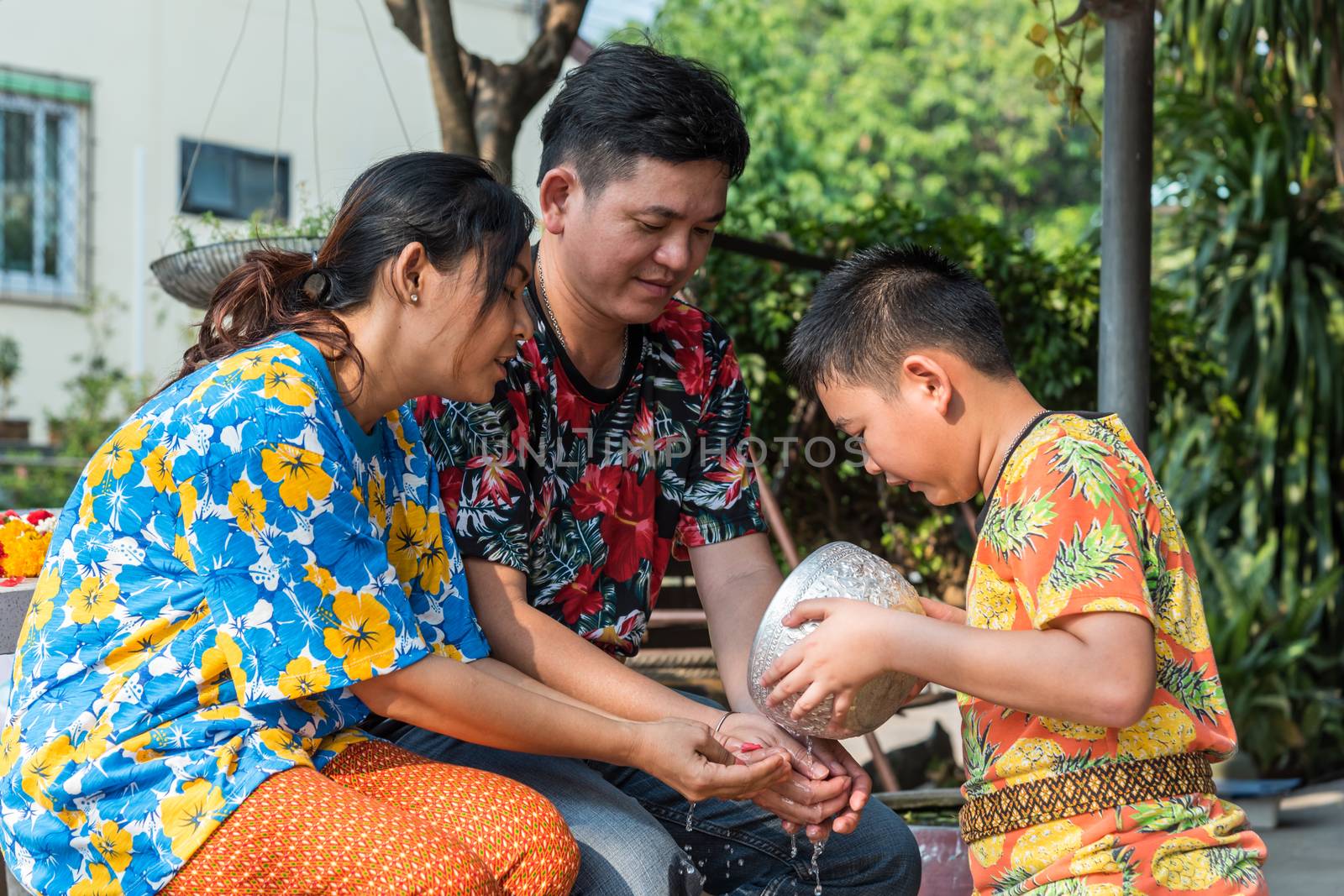 Ang Thong, Thailand - April 13, 2018 : Unidentified Asian young bathe with respect to parents by water have a jasmine and rose flower and aromatherapy in water in water bowl in Songkran Festival