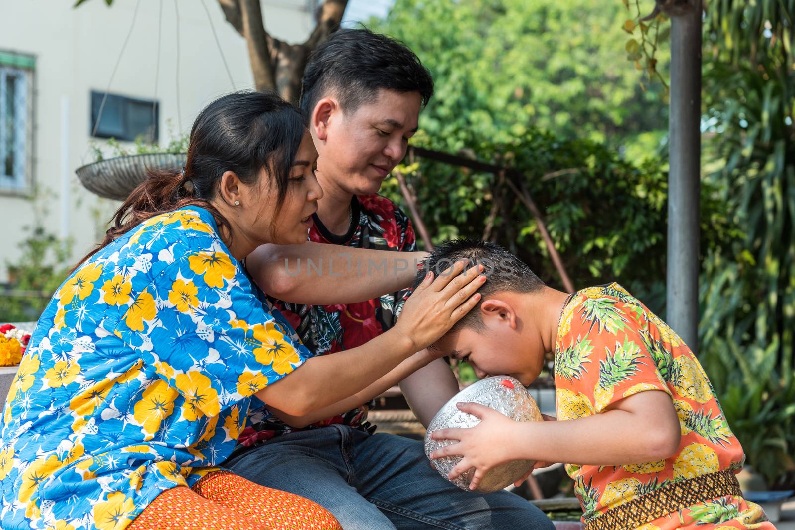 Ang Thong, Thailand - April 13, 2018 : Unidentified Asian young bathe with respect to parents by water have a jasmine and rose flower and aromatherapy in water in water bowl in Songkran Festival