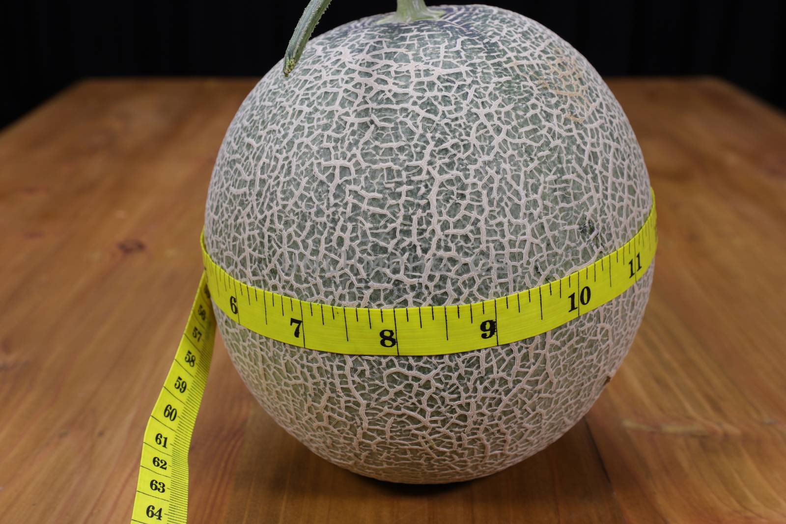 A cantaloupe and a measuring tape by Nawoot