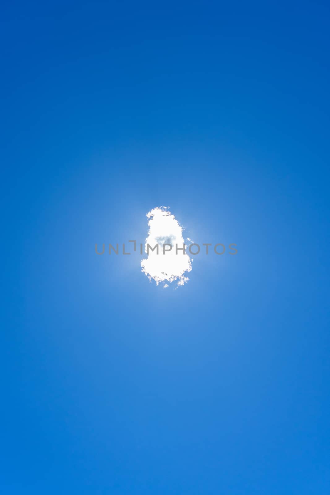 Cloud directly covering the sun in clean blue sky by Dumblinfilms