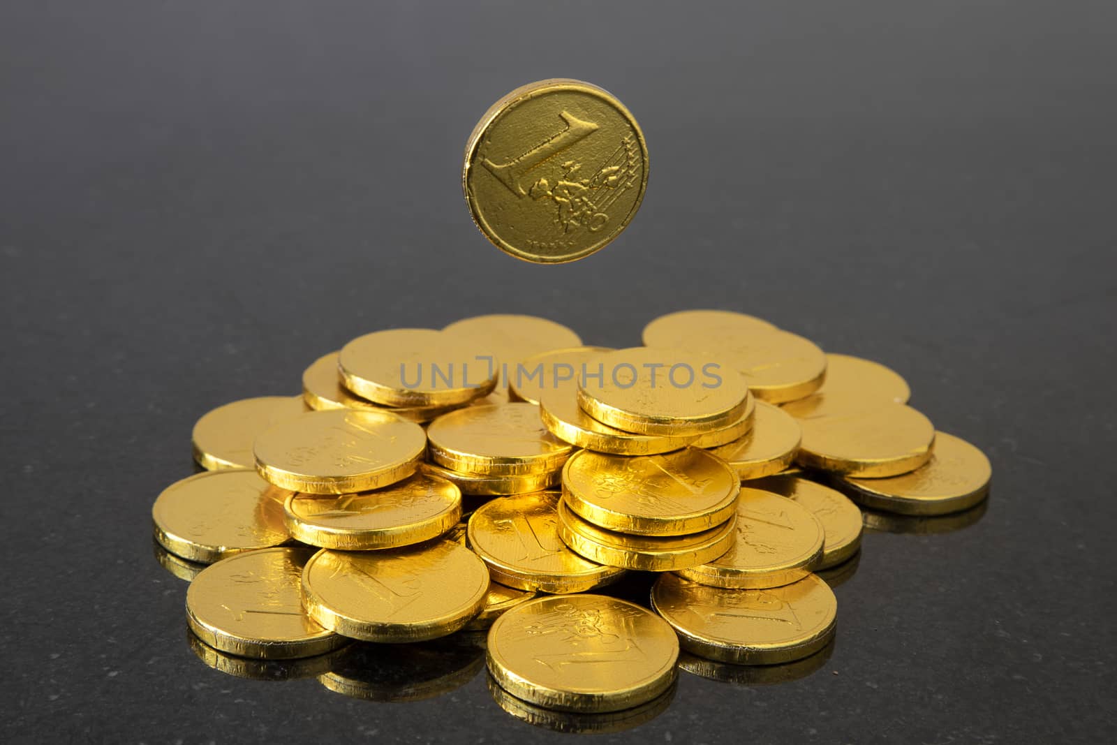 An image of a falling coin. Gold color, dark background.