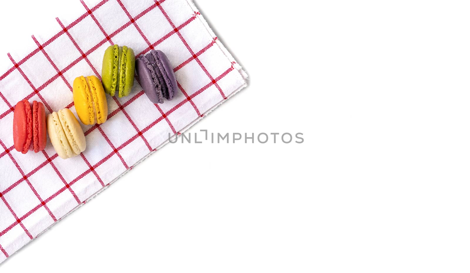 Colorful macaroons on red and white cotton cloth. Isolated on whire background.