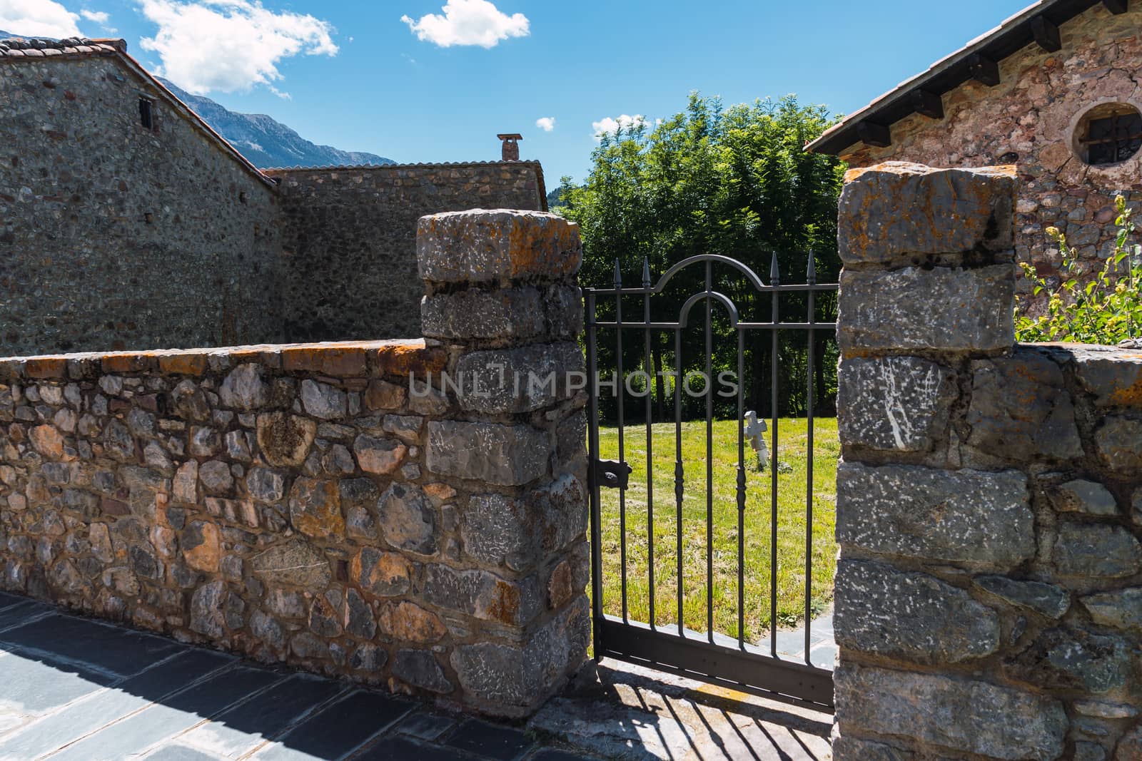 Gate of a very small cemetery in a village in the Pyrenees mountains. Gravestone, rest in peace.