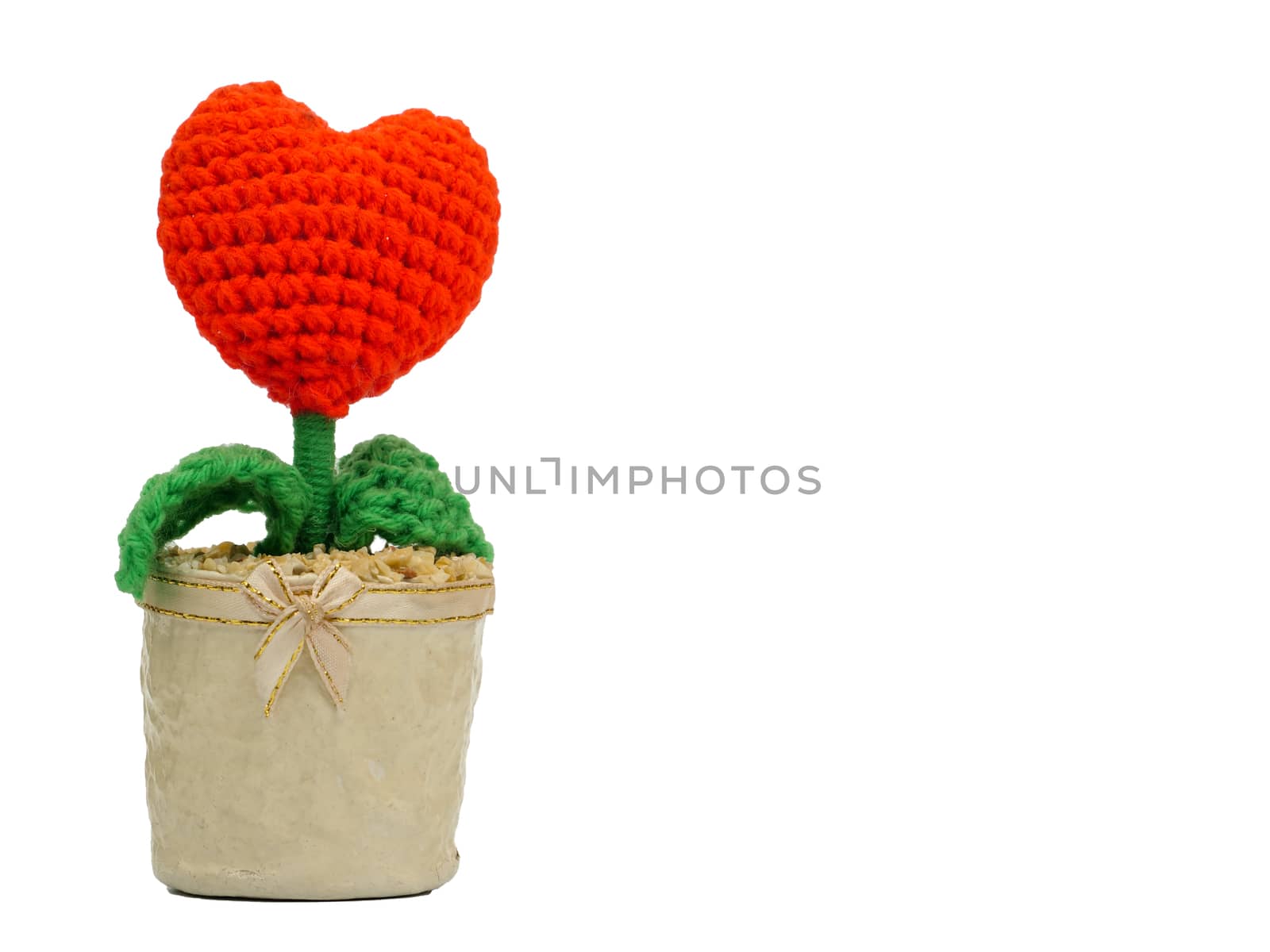 a symbolic love plant made of wool with a heart shape flower in a paper pot, isolated on white background