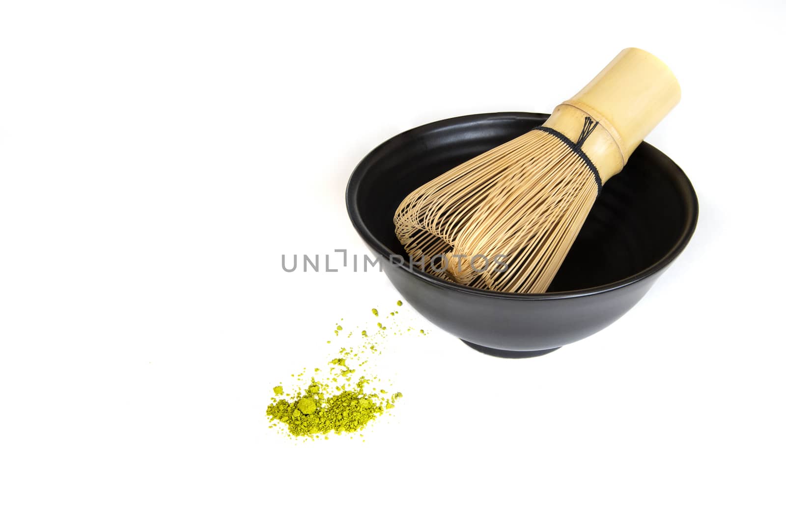 Japanese green tea powder stirrer and a black ceramic cup, isolated on white background.