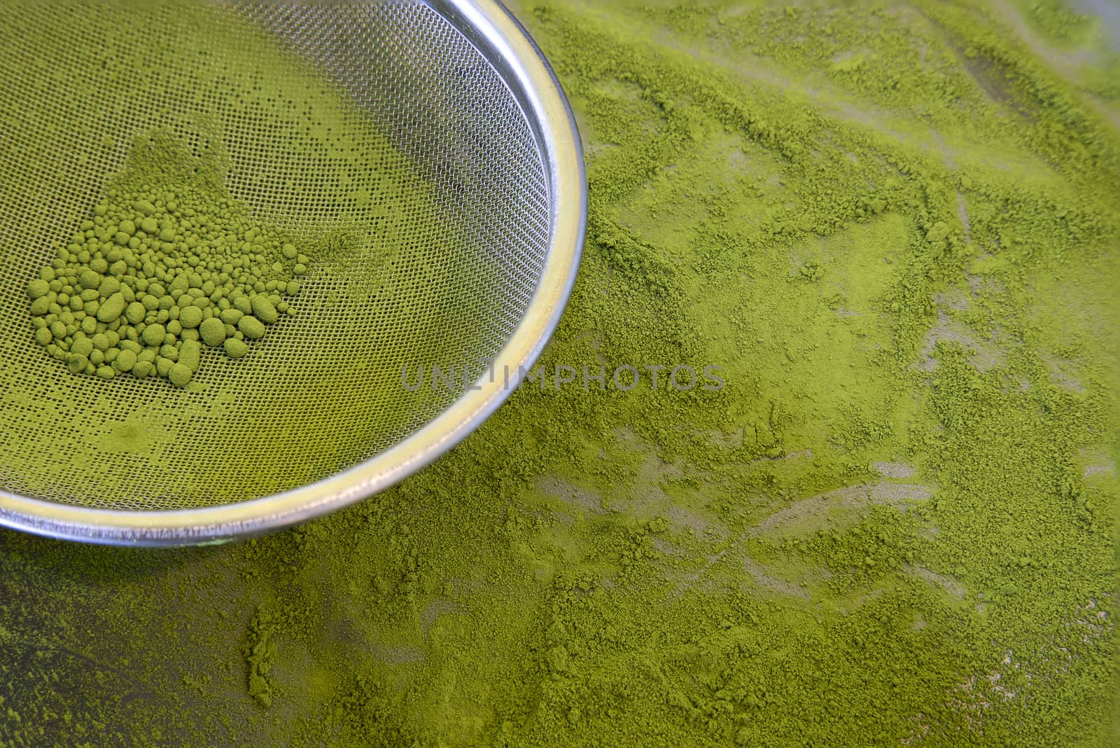 Making fine powered green tea. A tray filled with sieved fine green tea powder. Closeup, viewing above image.