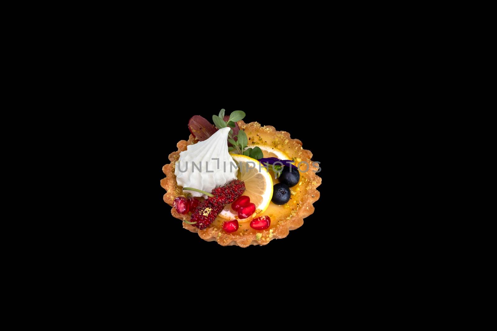 Lemon tart and fresh mixed fruits . Closeup, isolated on black background.