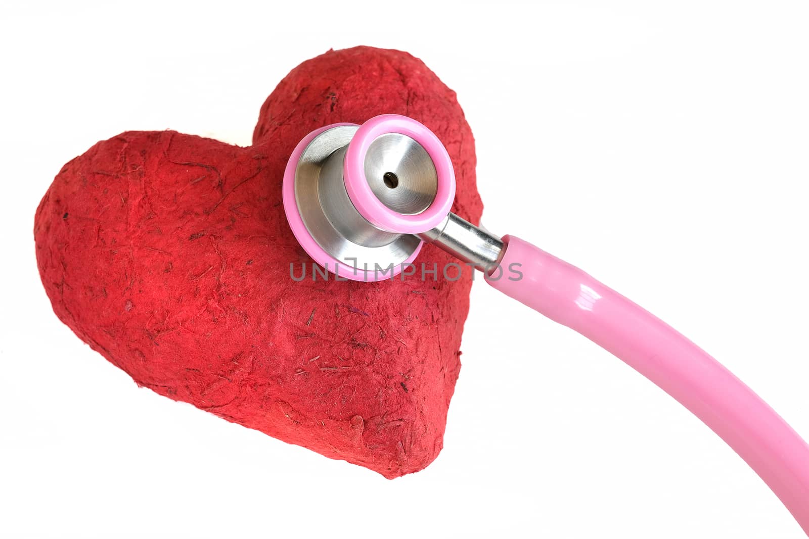 A stethoscope and a handmade red paper mache heart. Closeup, isolated on white background. Medicine and health concept.