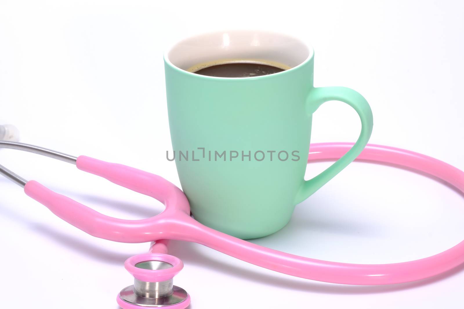 a pink stethoscope and a mug of hot coffee isolated on white background