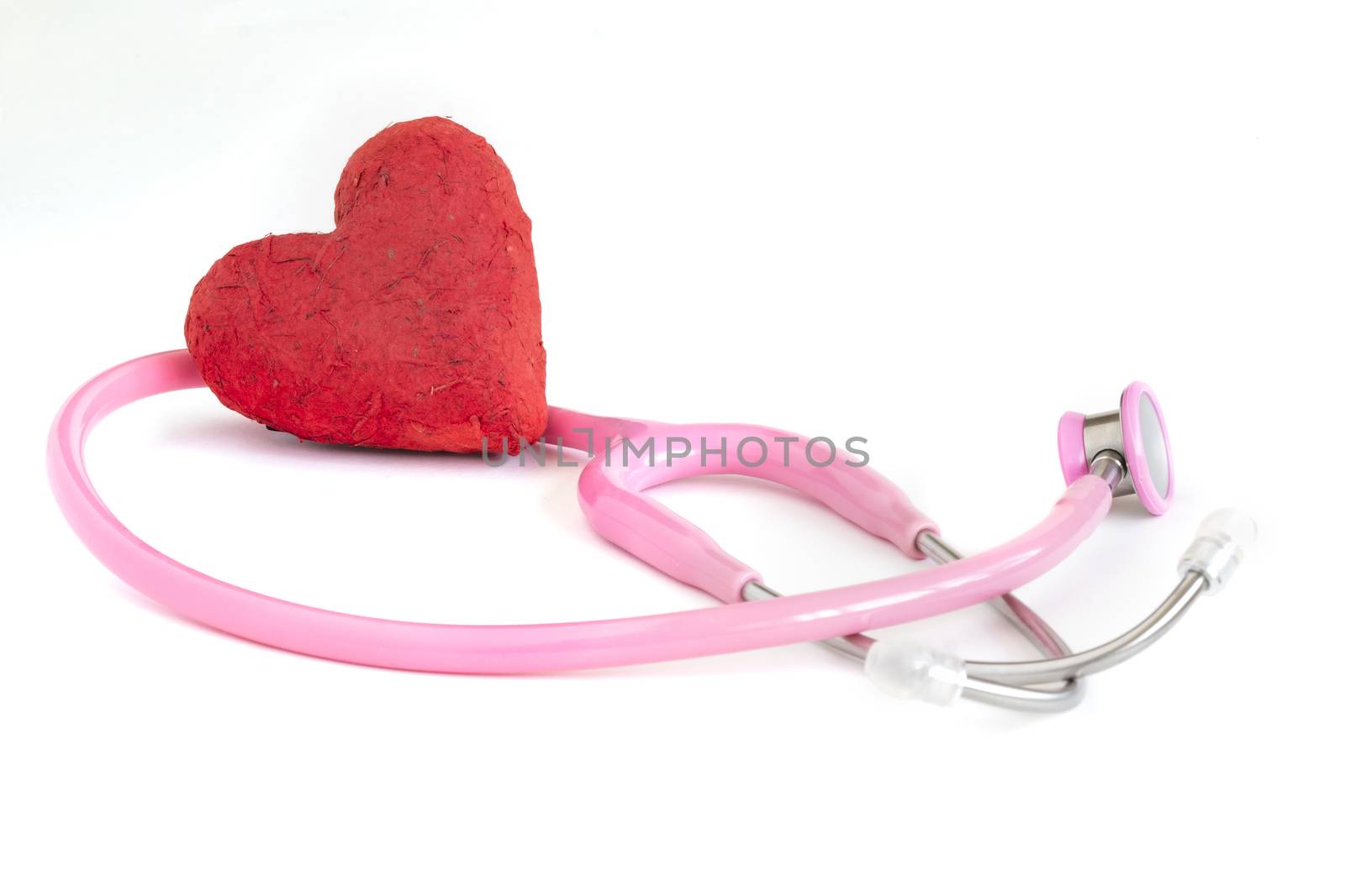 A stethoscope and a handmade red paper mache heart. Health care related concept