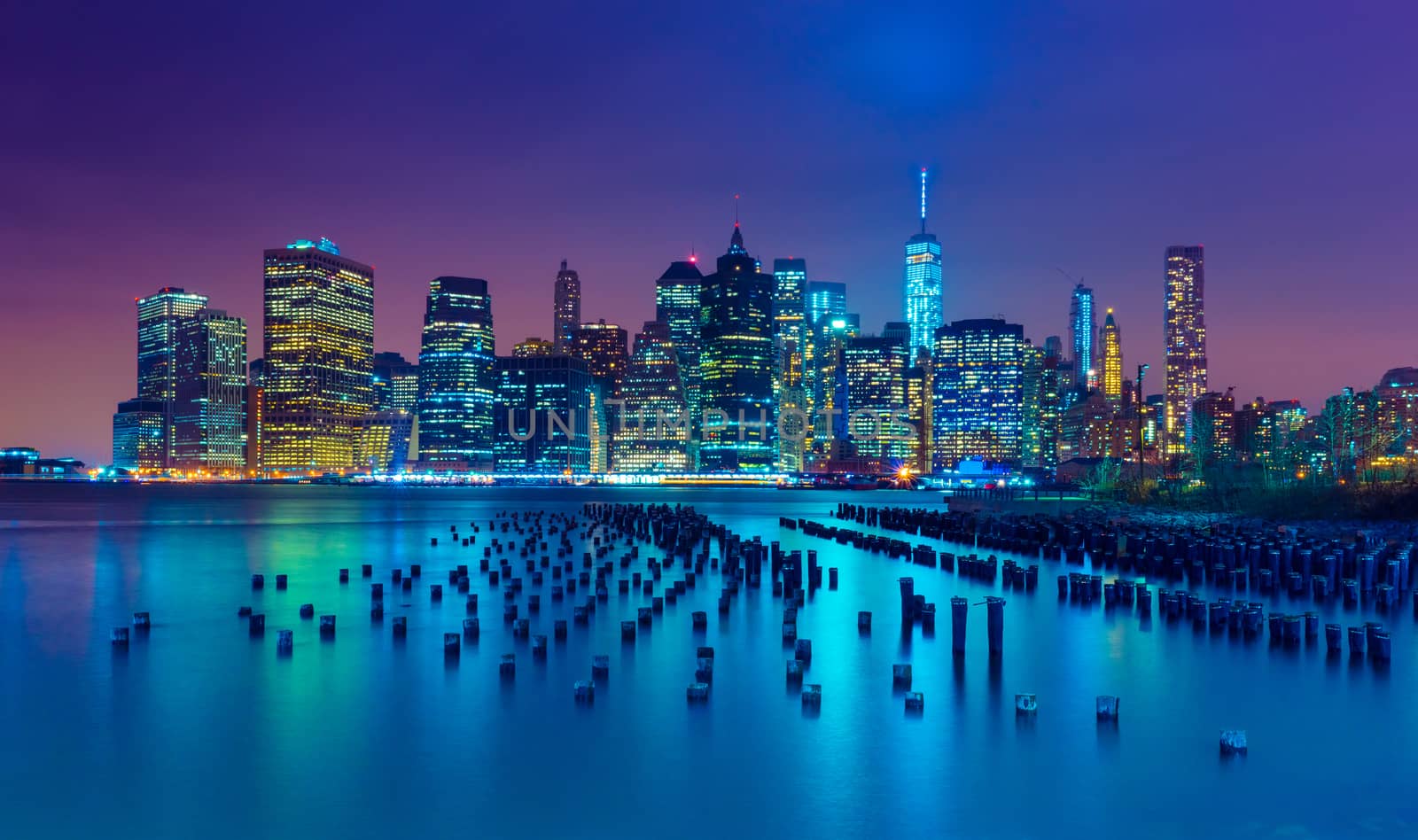 New York City at night. Manhattan skyline. Skyscrapers reflected in water. NY, USA