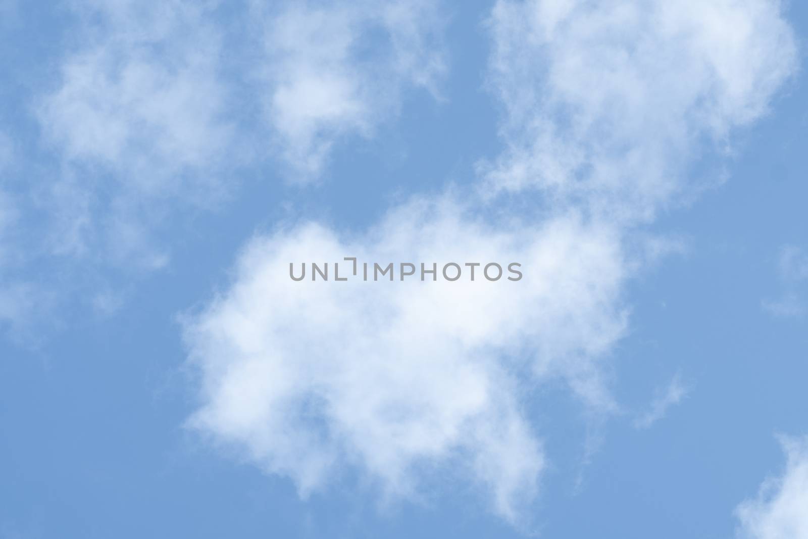 Blue sky background with soft fluffy white clouds.