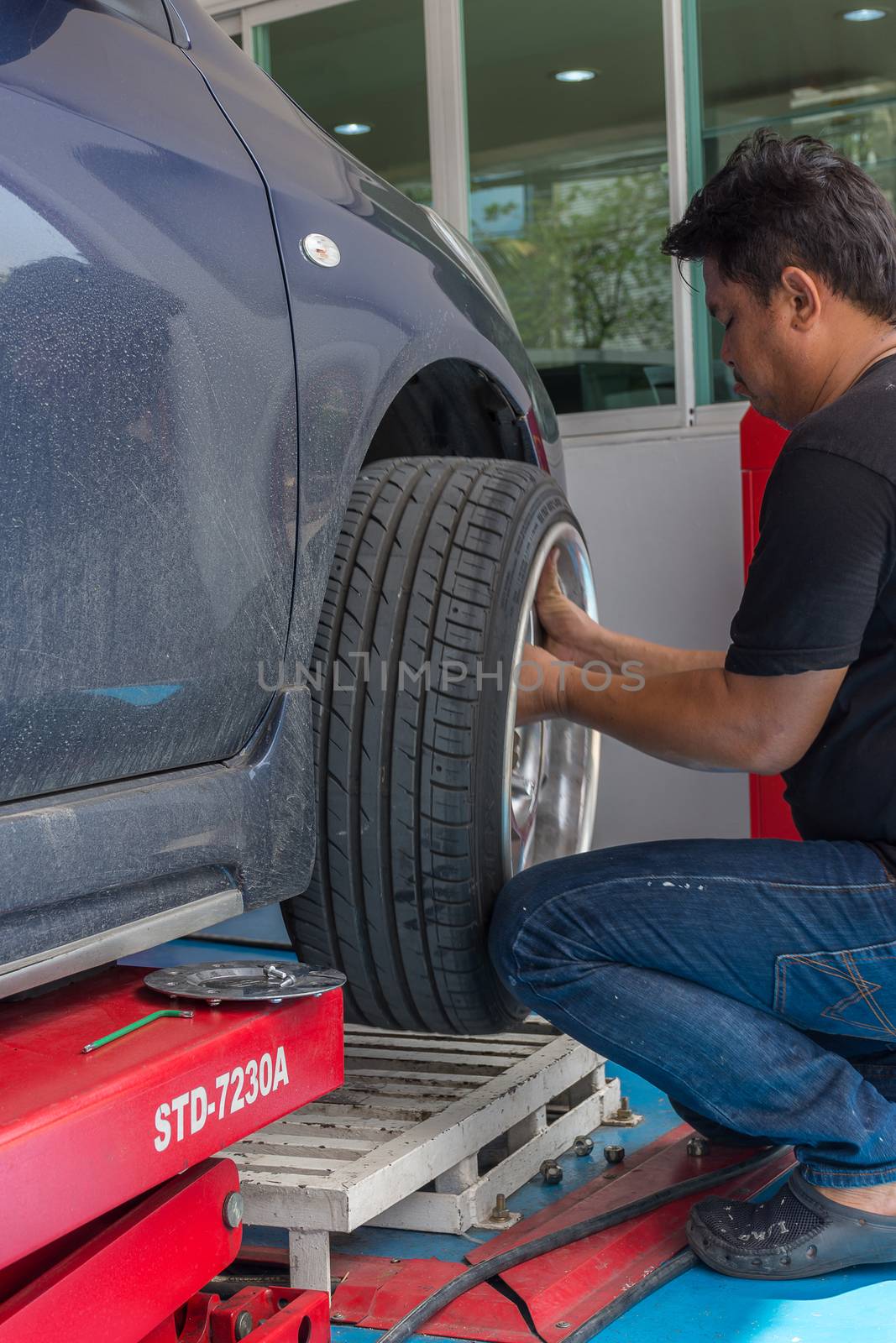 Bangkok, Thailand - May 20, 2016 : Unidentified serviceman checking suspension in a car at garage