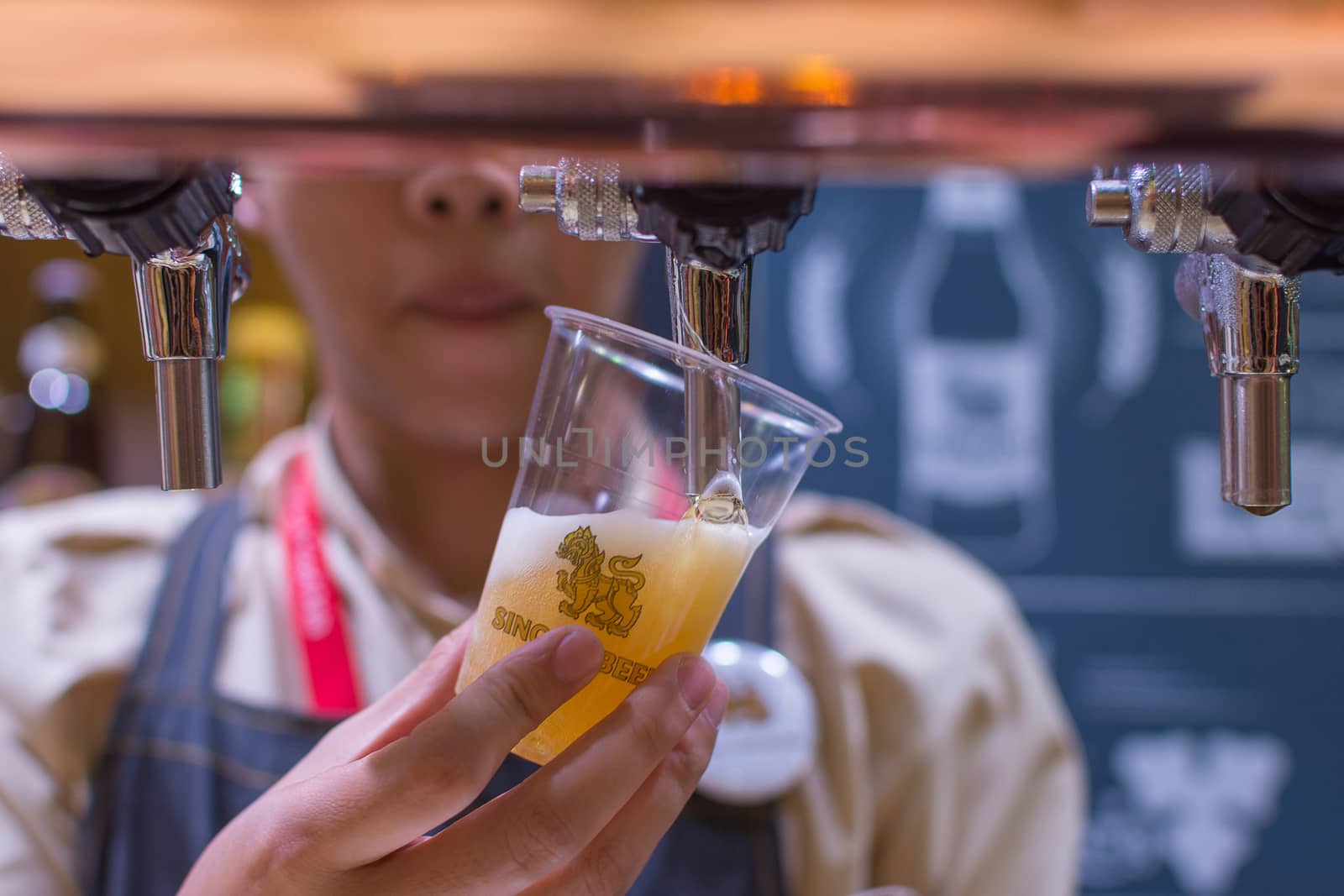 Bangkok, Thailand - May 28, 2016 : Unidentified barman or bartender pouring a draught lager beer from beer tap on counter for serving in a restaurant or pub.